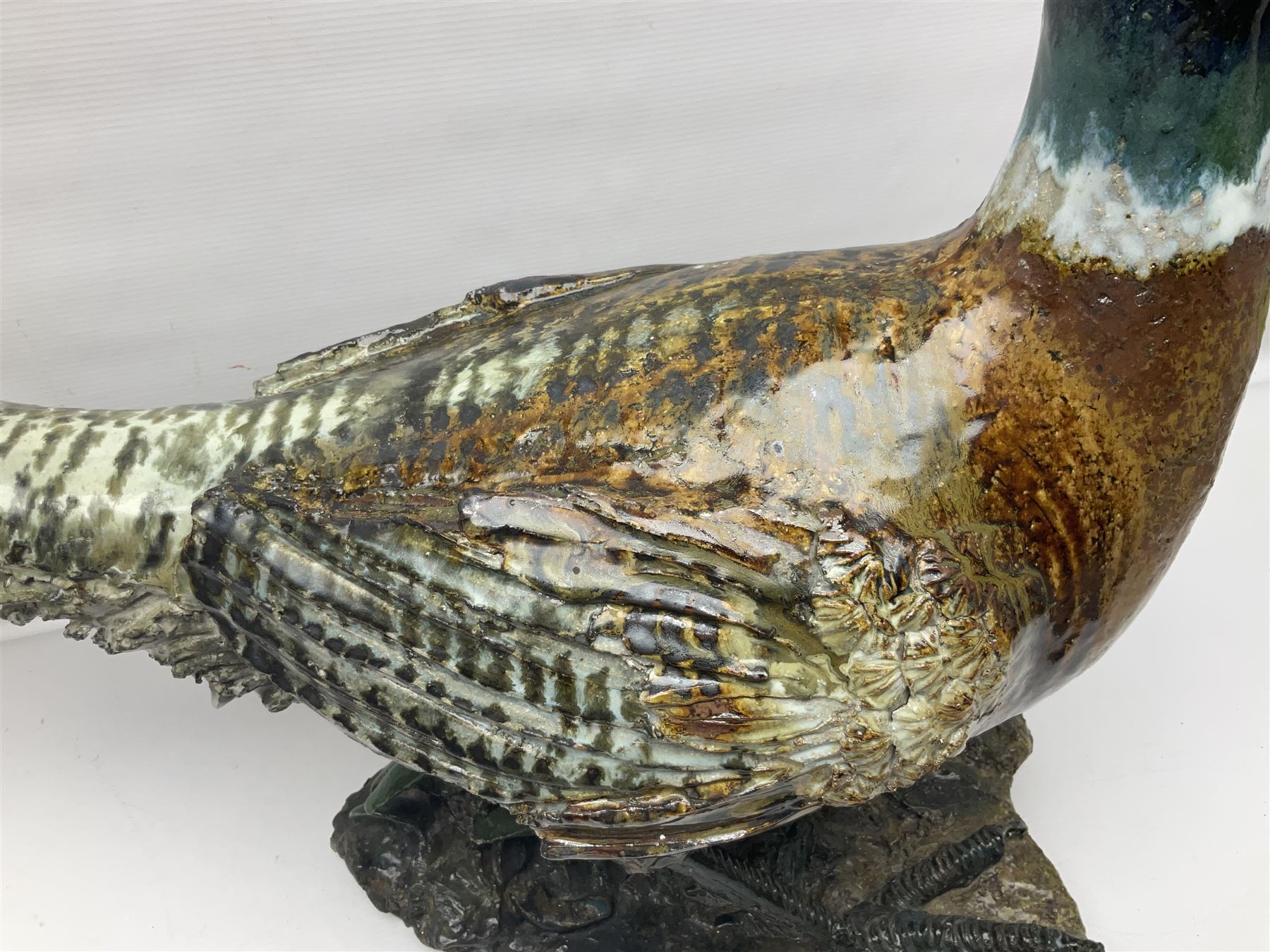 Large stoneware sculpture modeled as a Ring Neck Pheasant, upon a naturalistic base, H55cm, L78cm