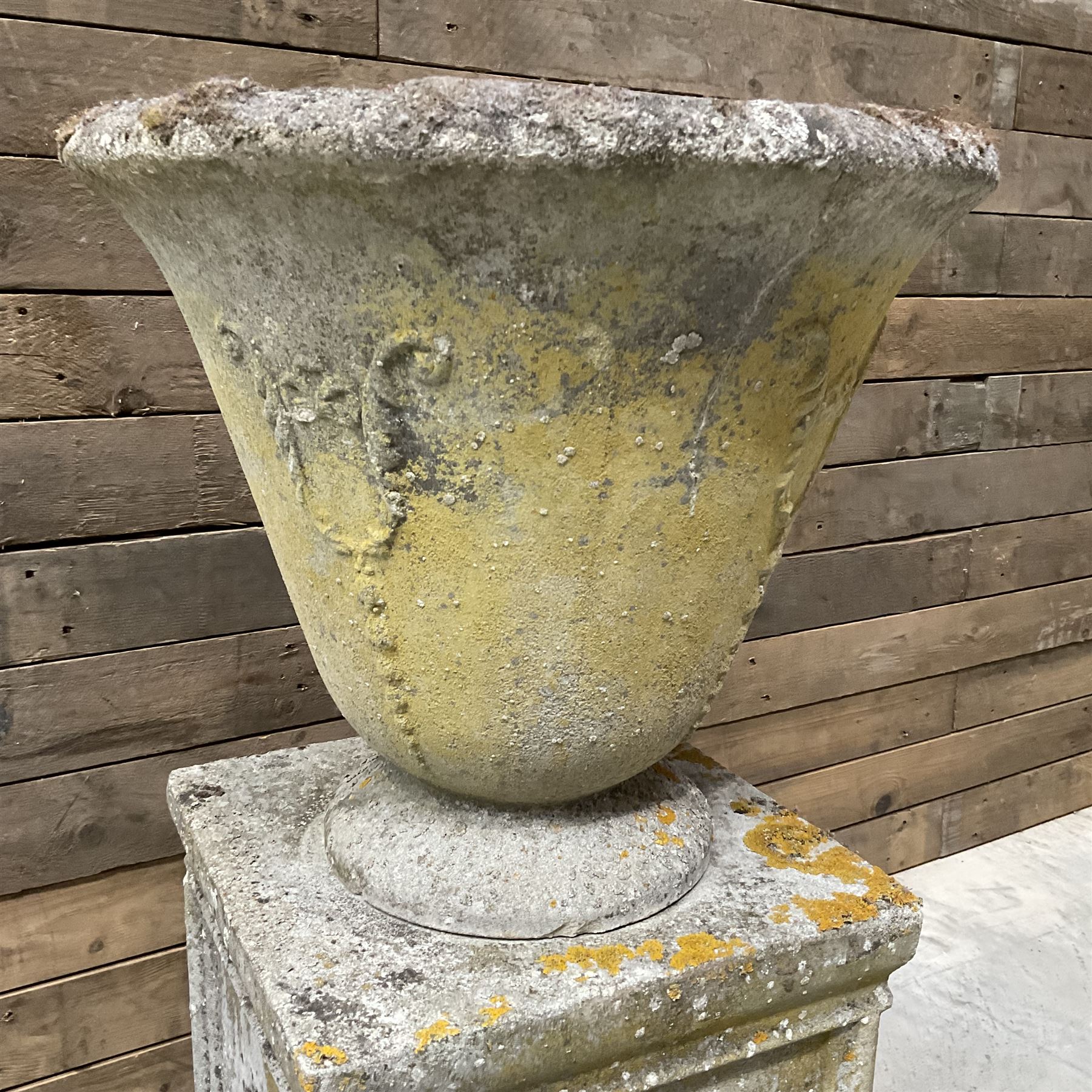 Cast stone vase shaped urn, mounted on square plinth