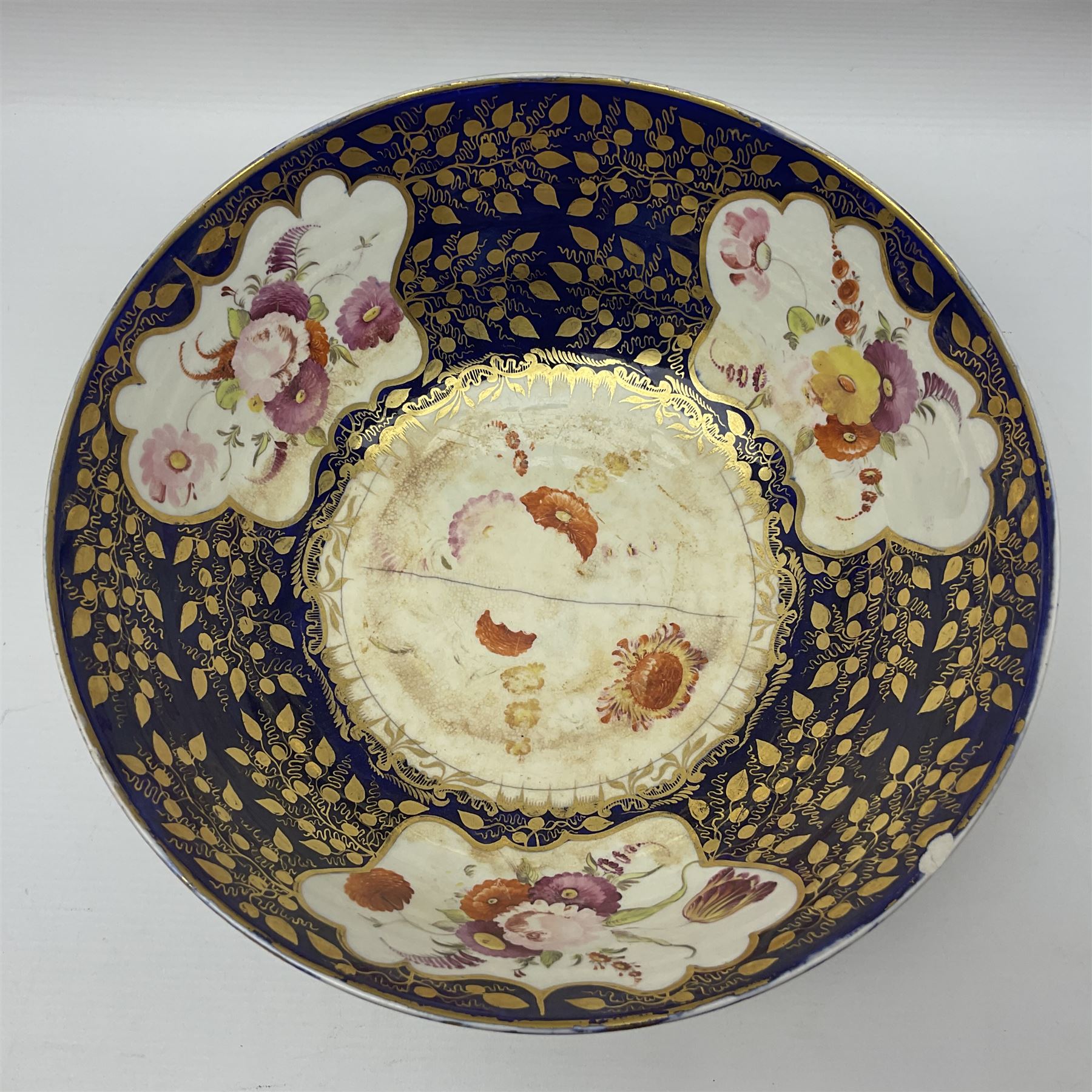 19th century continental bowl, decorated with hand painted floral sprays amongst gilt foliate decoration on a cobalt blue ground, D27.5cm