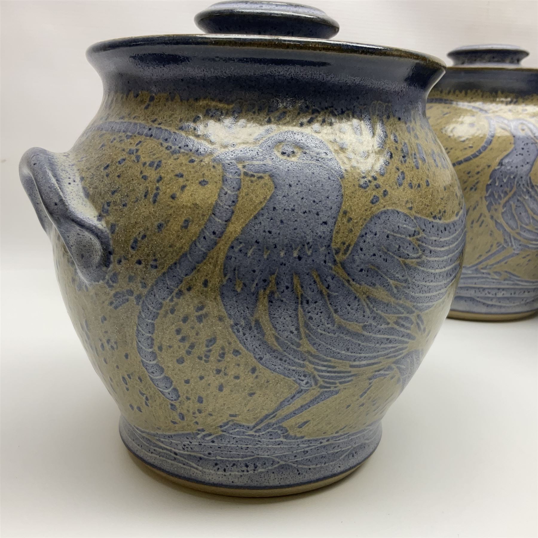 John Egerton (c1945-): set of five studio pottery stoneware twin handled jars with covers, decorated with blue birds upon a brown mottled ground, H20cm