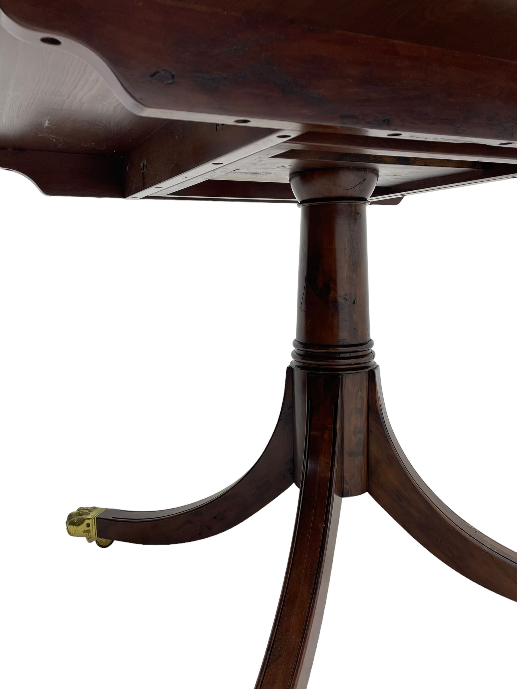 Georgian design inlaid chestnut wood centre table, the circular tilt-top inlaid with satinwood banding, gun barrel turned pedestal on four out-splayed supports, cast brass hairy paw castors, stamped 'P.H.R & Co. Holt, England' 