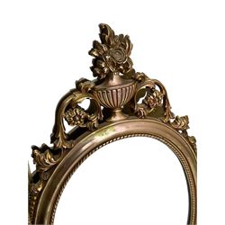 Regency revival style gilt framed oval mirror, the frame with laurel swags topped with urn and flame finial, beaded chain and ram's head motifs, bevelled glass pane; three additional gilt framed mirrors to include one oval and two rectangular (4)