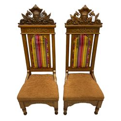 Set of six 20th century Carolean design oak high back chairs, the pediment carved with dragons and central Green Man mask with trailing foliage, the backs upholstered in striped fabric, on turned front supports