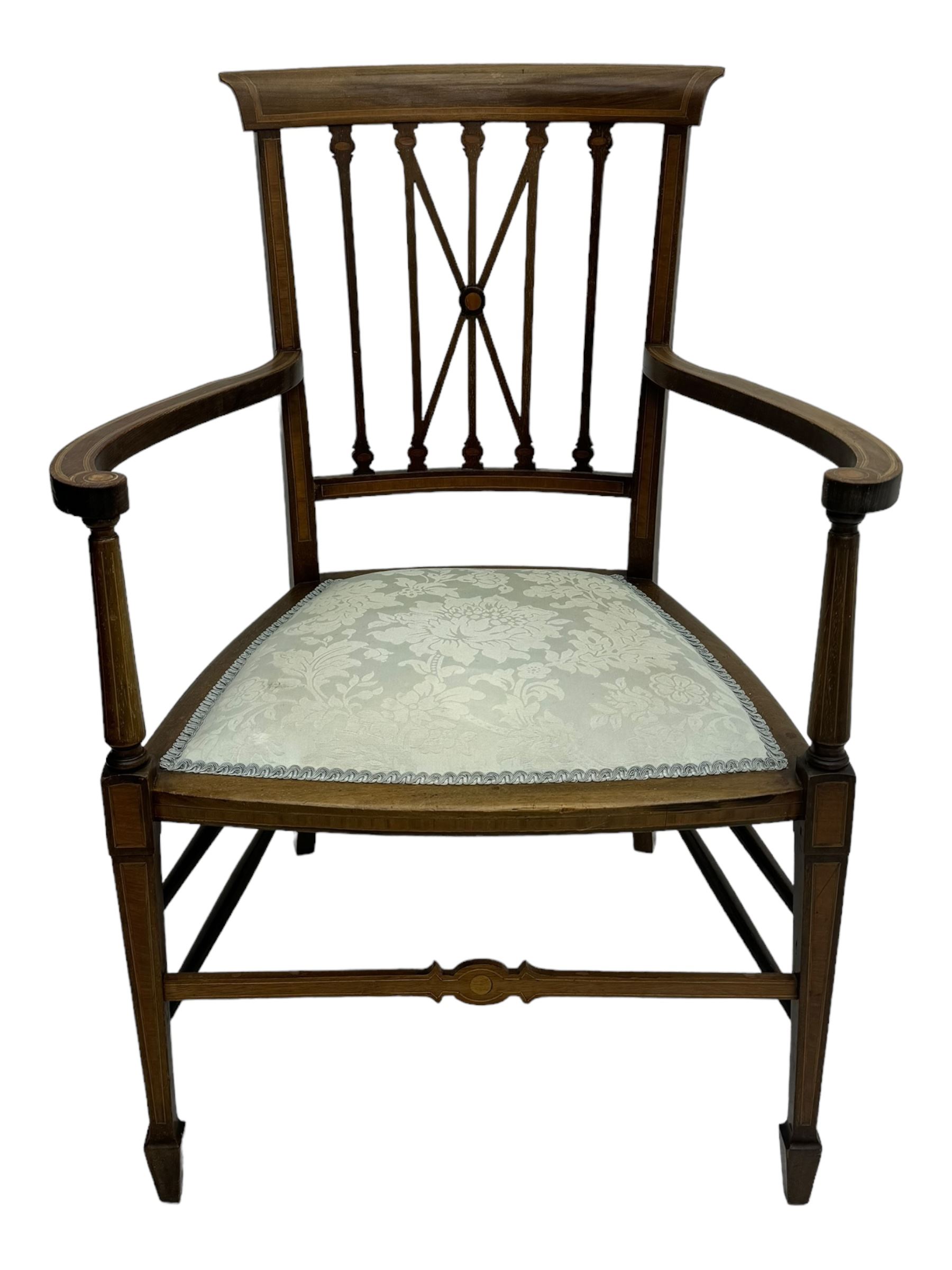 Edwardian inlaid mahogany armchair, curved top rail above spindle backrest with central X-shaped splat, the arms supported by turned uprights, over upholstered padded seat in pale blue damask fabric, on tapered supports with spade feet