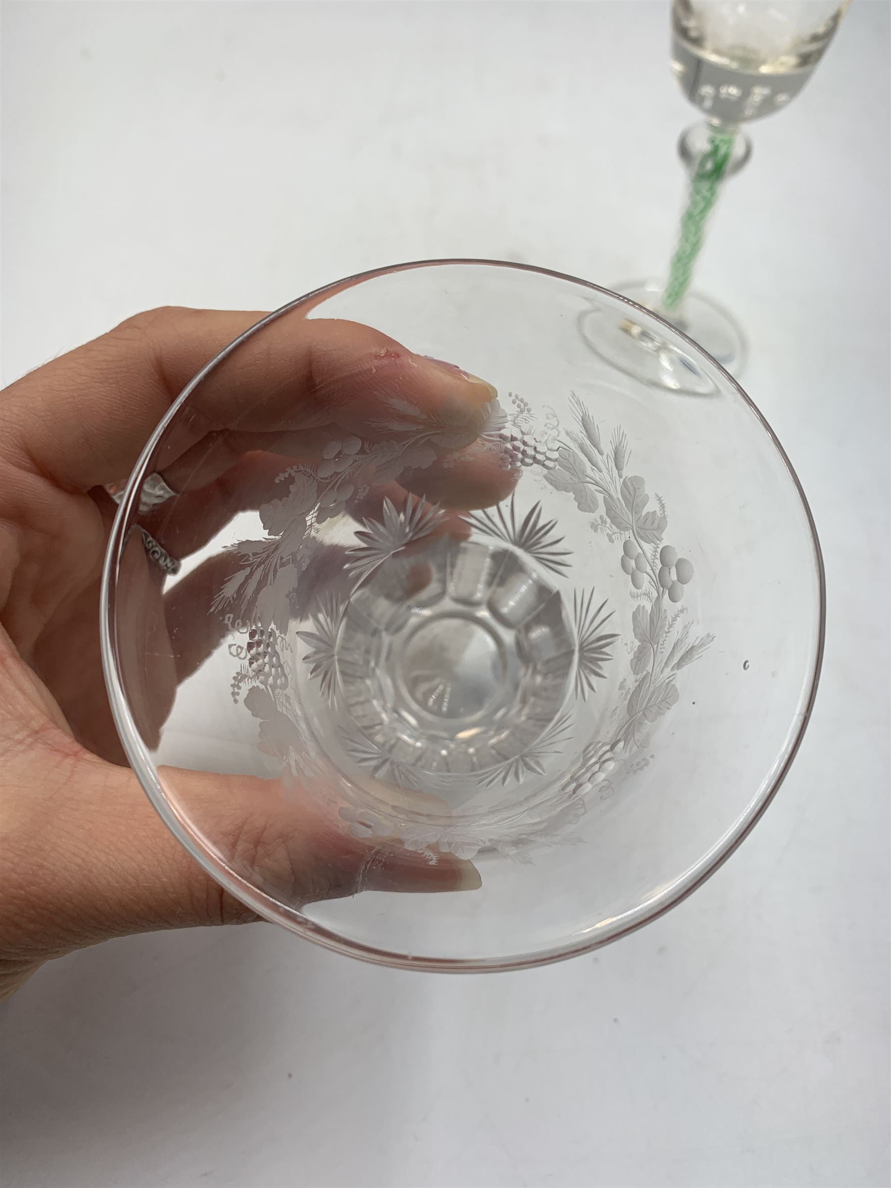 19th century continental liqueur glass, circa 1870, bucket bowl with bubble decoration, the tapered stem with green and white strands, H12.5cm; together with a Victorian aperitif glass, trumpet bowl decorated with foliate and fruiting vines, H10cm (2)