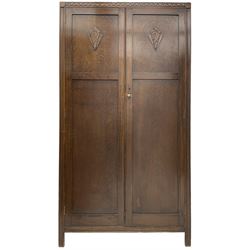 Mid-20th century oak wardrobe, enclosed by two panelled doors with carved mounts, the interior fitted with drawers and shelves 