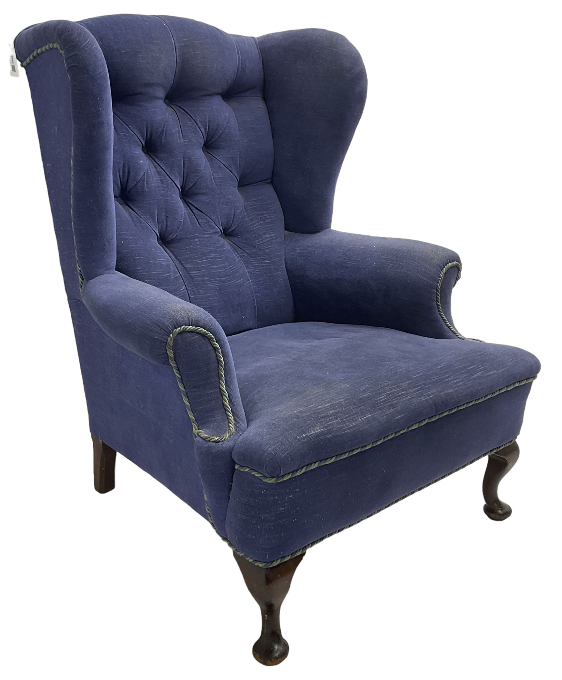 Early 20th century wingback armchair, upholstered in buttoned blue fabric, rolled and scrolled arms, on cabriole feet