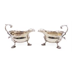 Near pair of George II silver sauce boats, each of oval form with shaped rim and capped flying scroll handle, upon three scroll mounted feet, hallmarked David Hennell, London 1758, H12cm