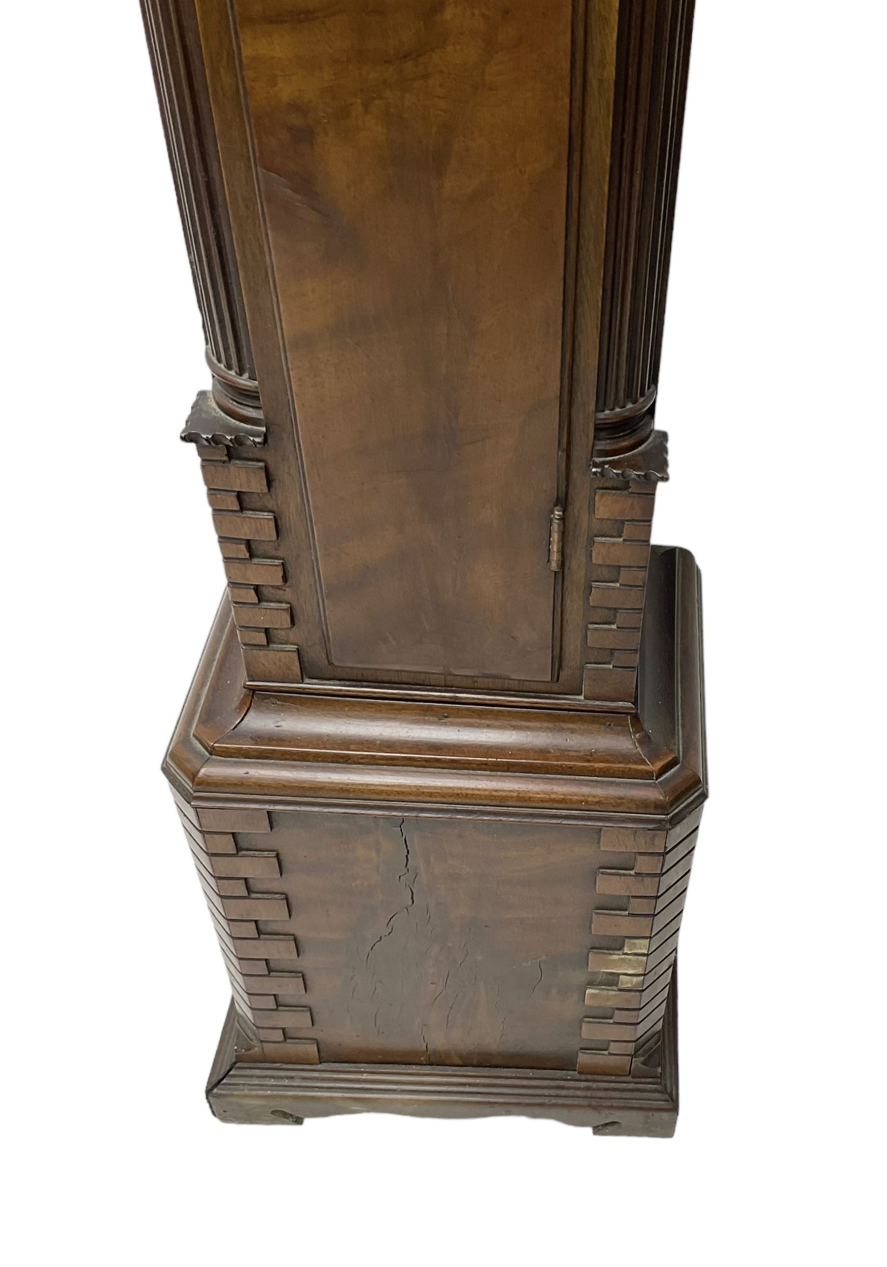 20th century - Chippendale design mahogany 8-day Grandmother clock with a profusely carved and decorated swan's' neck pediment, break arch hood door flanked by reeded pilasters with wooden capitals, trunk with a carved frieze, canted corners, three quarter reeded pilasters and a long trunk door with a wavy top, plinth with carved brickwork to the corners and raised on a shaped base, brass dial with a plain centre, cast spandrels and a silvered 