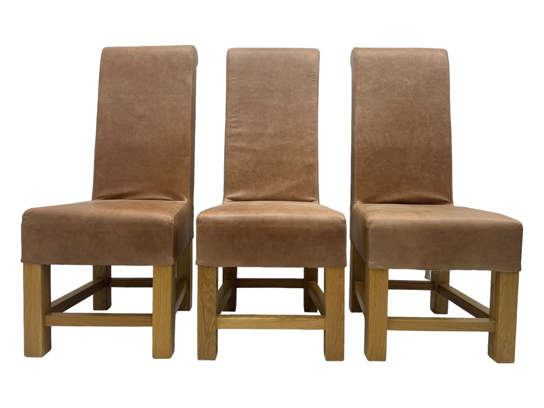 Set of six contemporary light oak dining chairs, each with high back and seat upholstered in pale tan leather, on square supports connected by H-stretcher