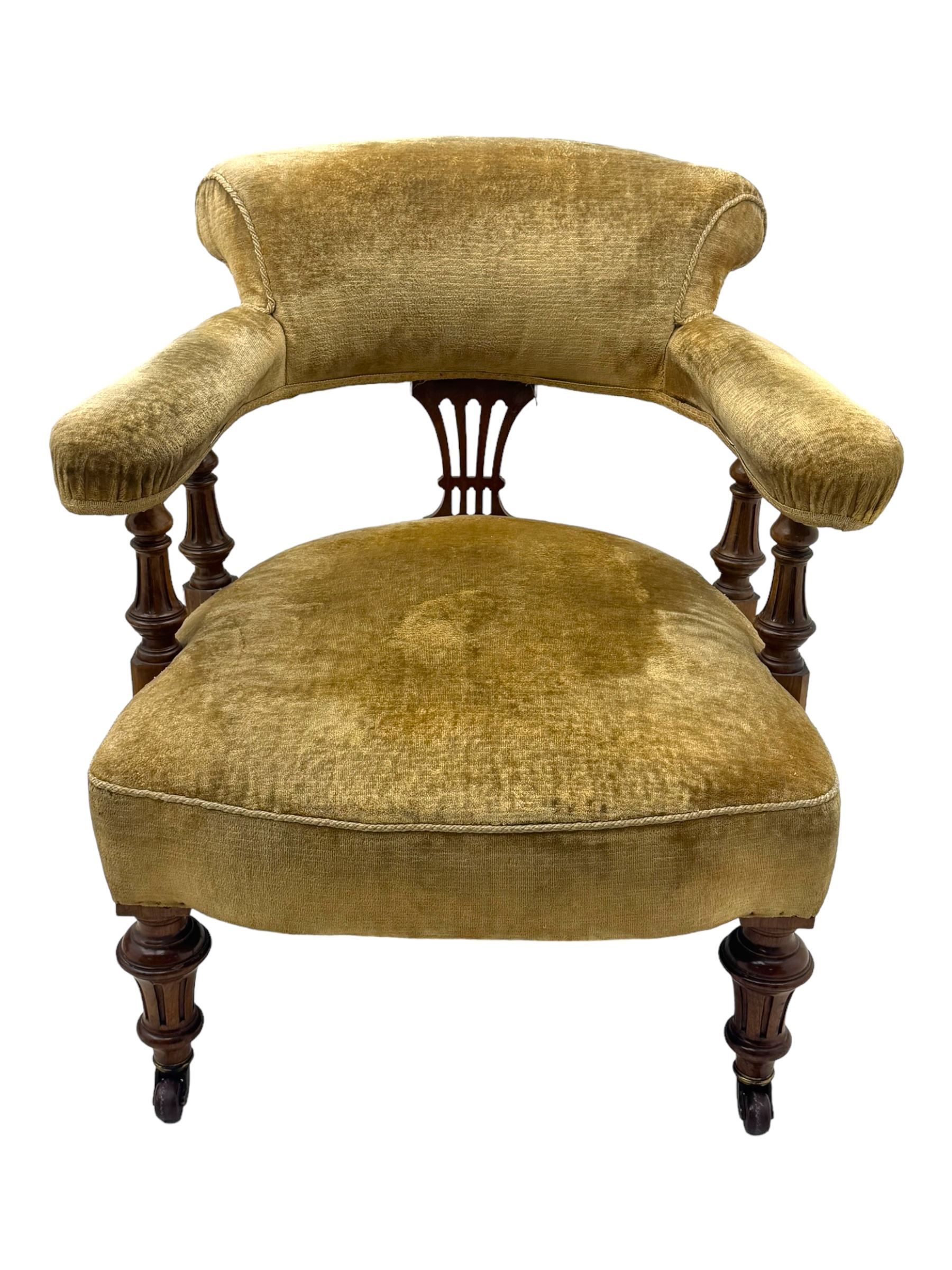 Victorian pair of mahogany armchairs, upholstered in gold velvet fabric, each with curved back, pierced splat and scroll arms, one with rounded seat and the other square, on turned front supports with castors