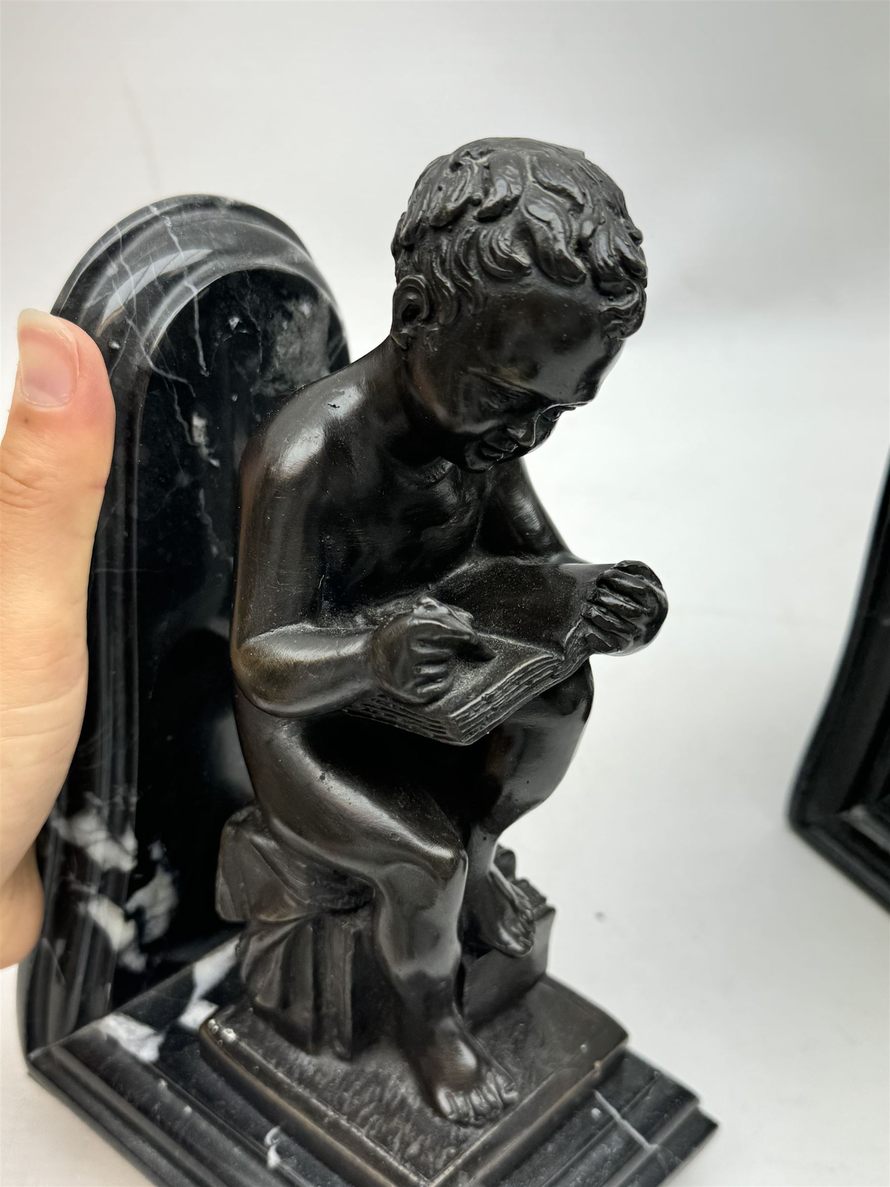 Pair of marble and bronzed bookends, modelled as putti reading, H22cm