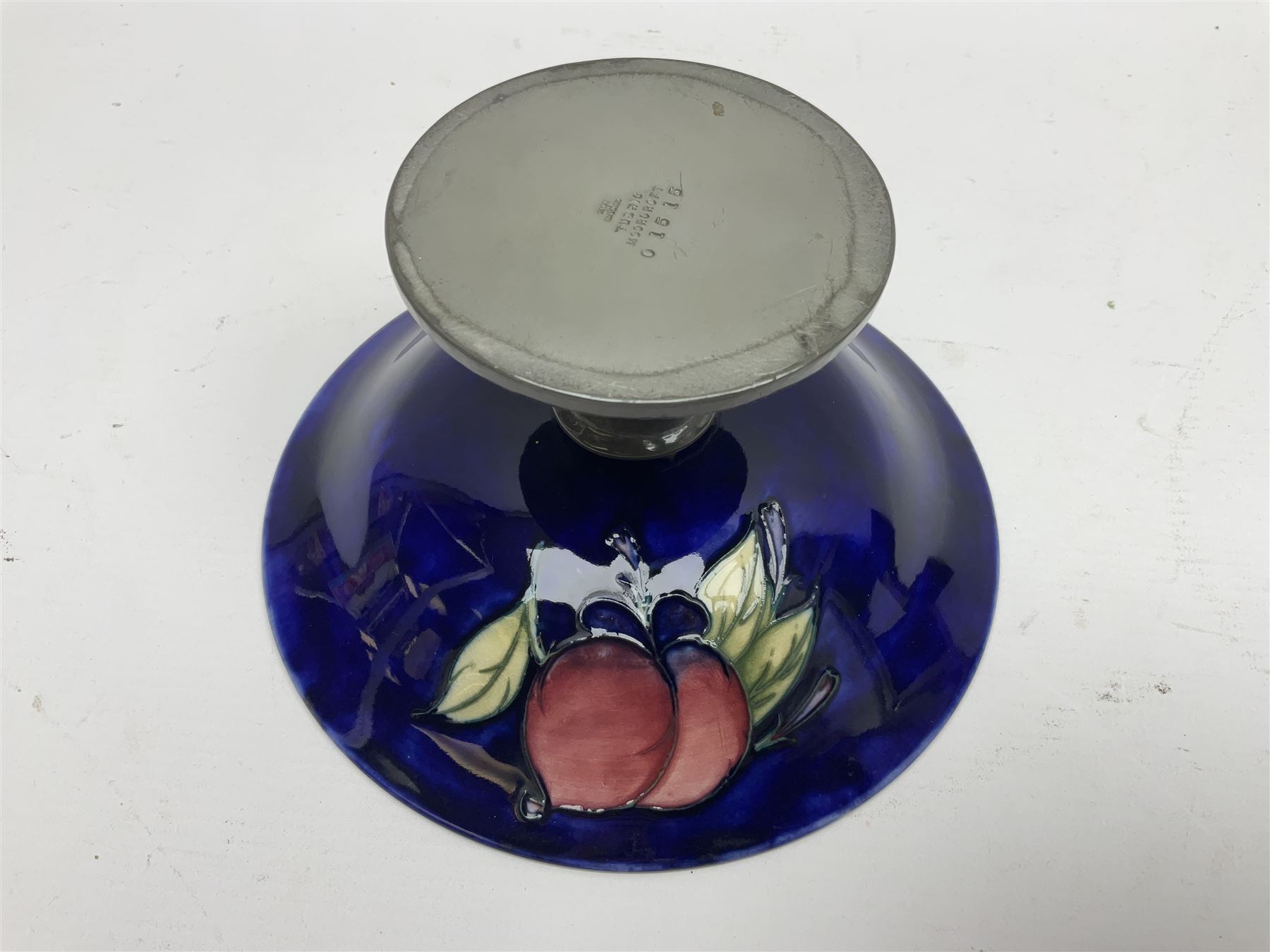 Moorcroft small pedestal dish decorated in the Wisteria pattern against a dark blue ground raised to a Tudric pewter stand, impressed beneath Tudric, Moorcroft, H9cm