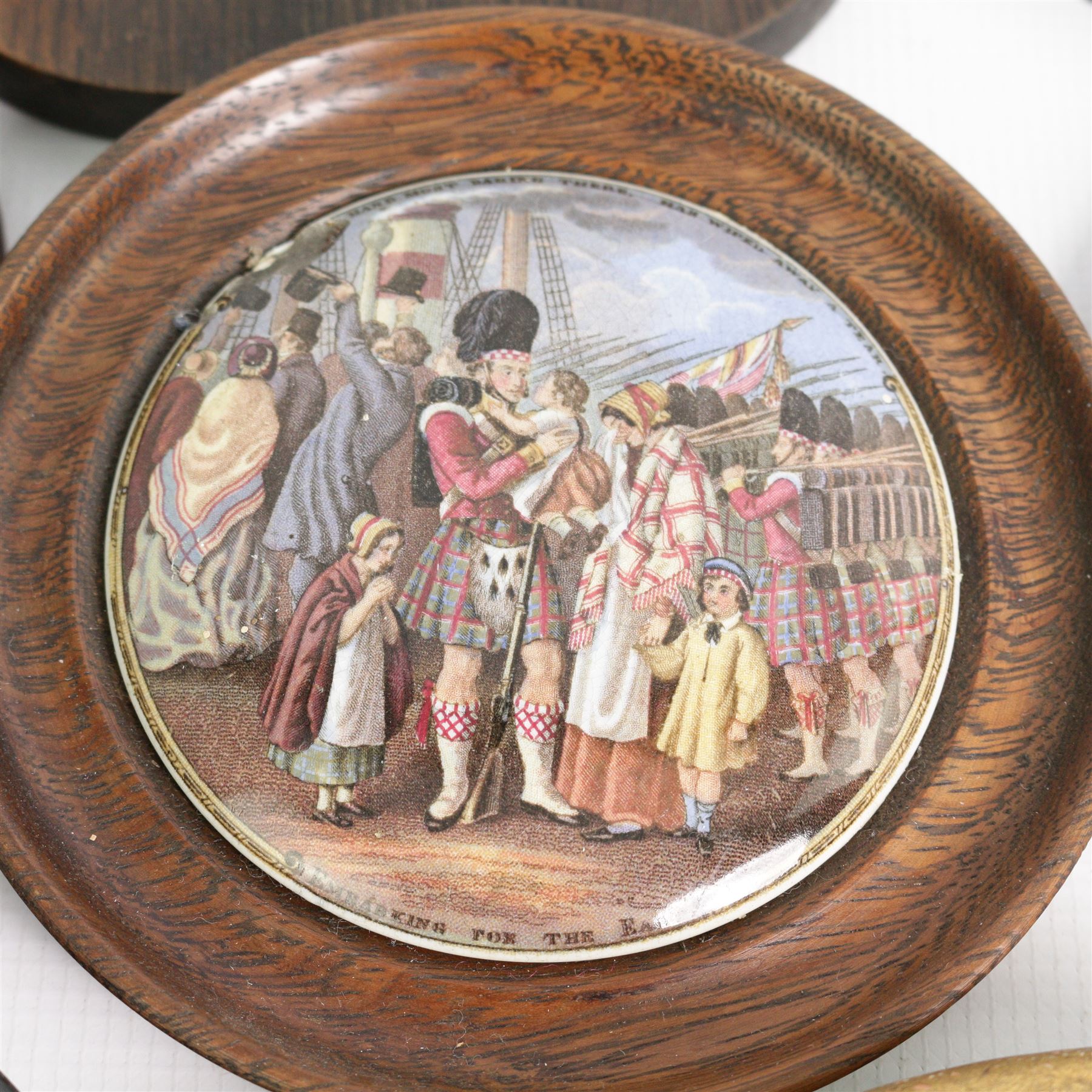 Collection of Victorian Pratt ware and other pot lids including 'Embarking for the East', 'The Snow Drift', 'Garibaldi', The Game Bag', 'The Enthusiast' and others, framed (13)