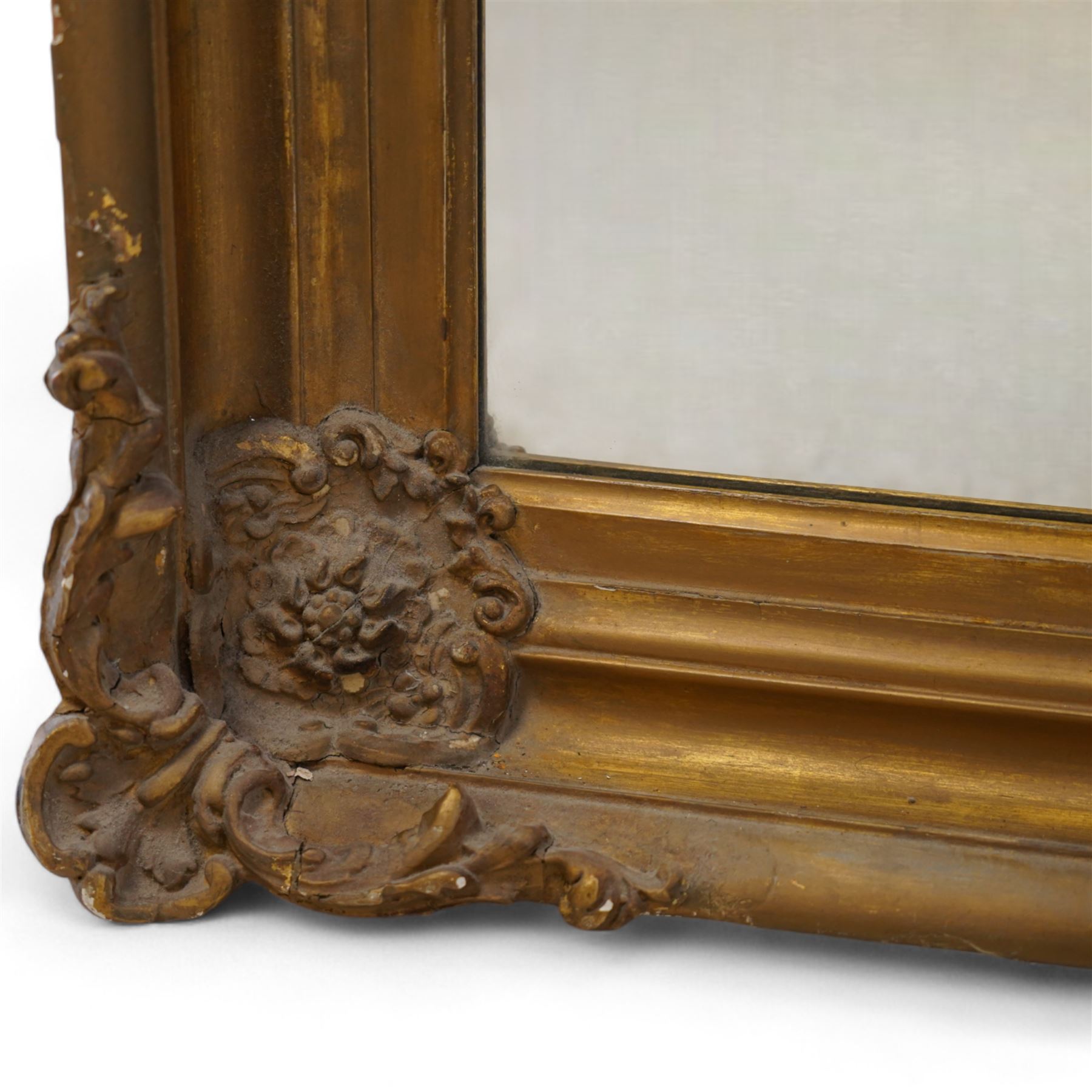 19th century gilt wood and gesso framed wall mirror, moulded rectangular swept frame, each corner decorated with floral cartouche and extending foliage, plain mirror plate 