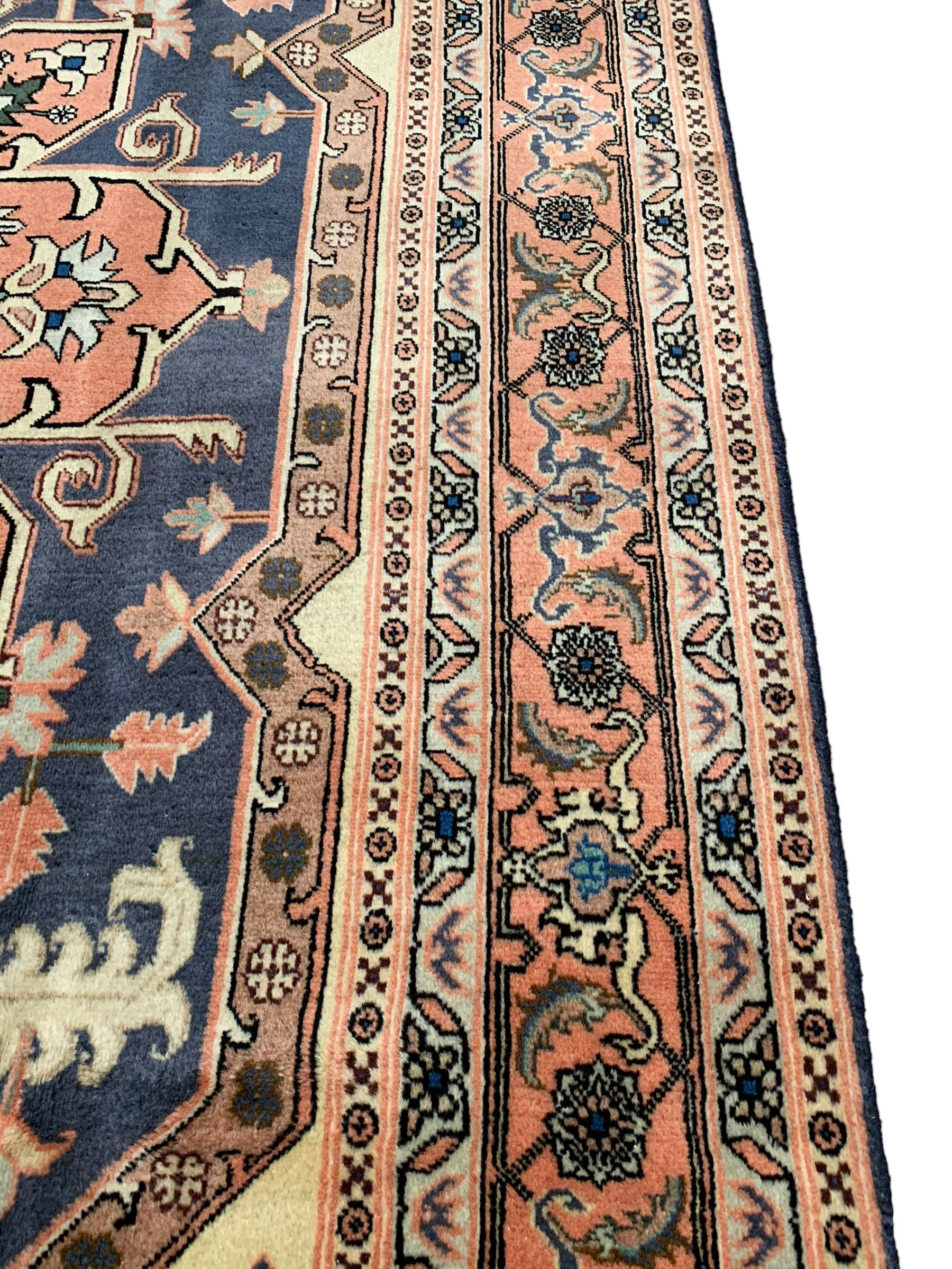 Persian ivory and peach ground, overall geometric design, the field with central star medallion surround stylised leaf motifs, guarded geometric design border