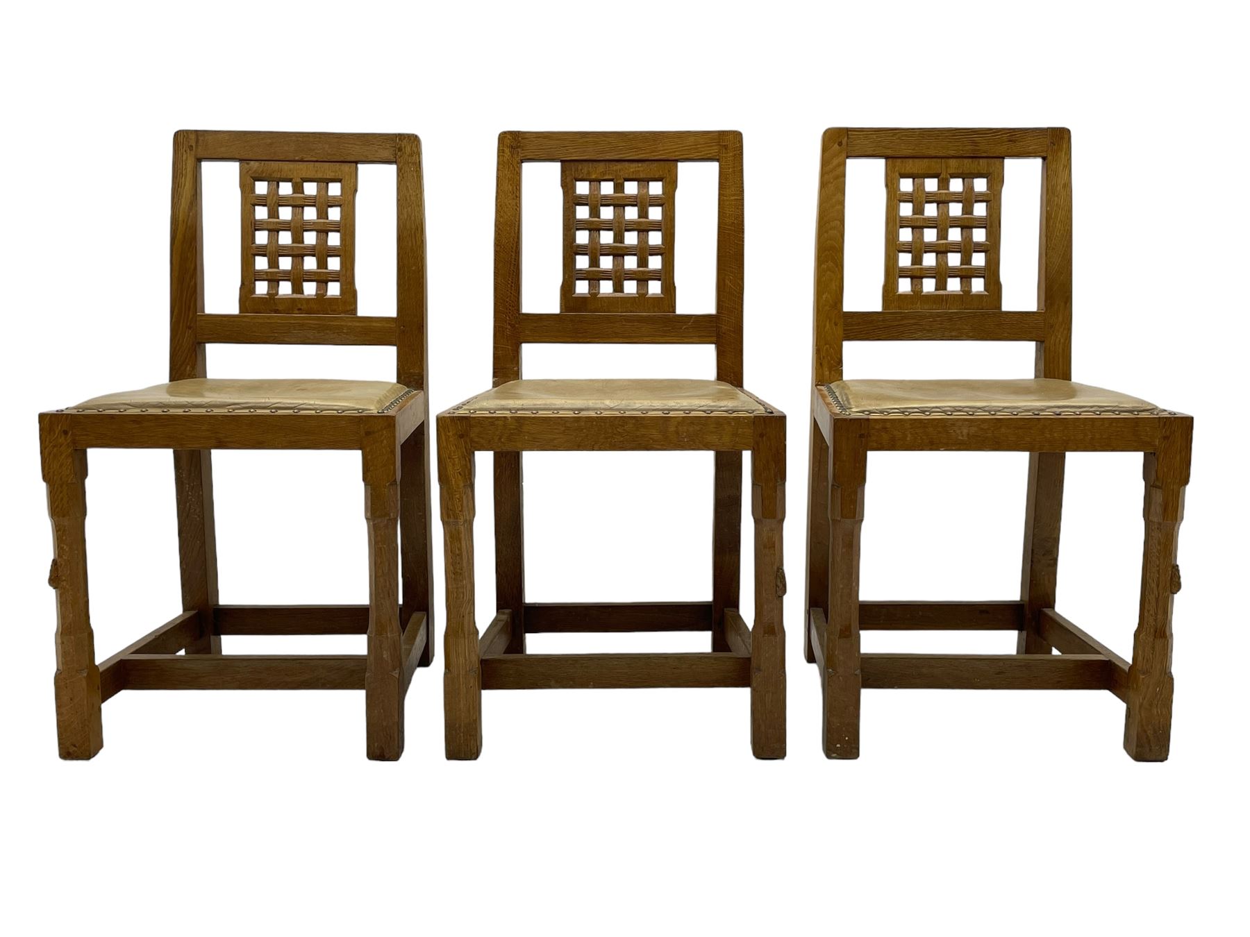 Rabbitman - set of six (5+1) oak dining chairs, pierced and carved lattice back, leather upholstered seat with stud band, on octagonal supports united by stretchers, carved with rabbit signature, by Peter Heap of Wetwang 