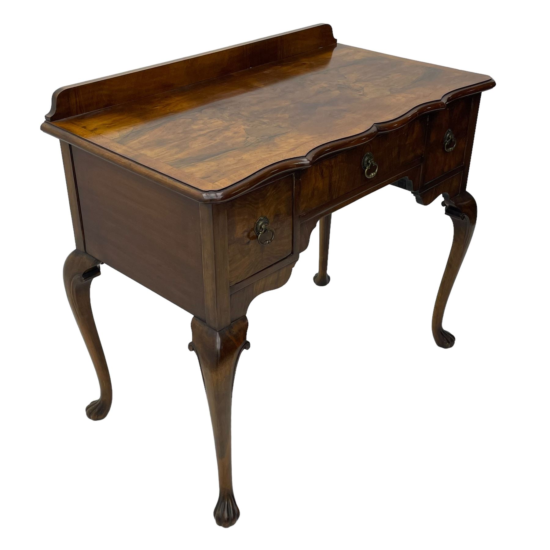 Mid-to-late 20th century figured walnut side table, raised back over figured top with cross banding and shaped front, fitted with three drawers, on cabriole supports with carved terminals 