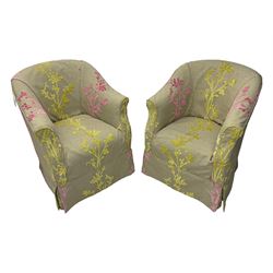 Pair of tub-shaped armchairs, mahogany frame loosely covered by branching floral pattern cover in pink and  yellow hues, skirted base, on concealed splayed rear and tapered front supports