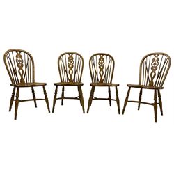 Set of four elm Windsor dining chairs, hoop and stick back with shaped wheel splat, dished seat on turned supports united by crinoline stretcher 