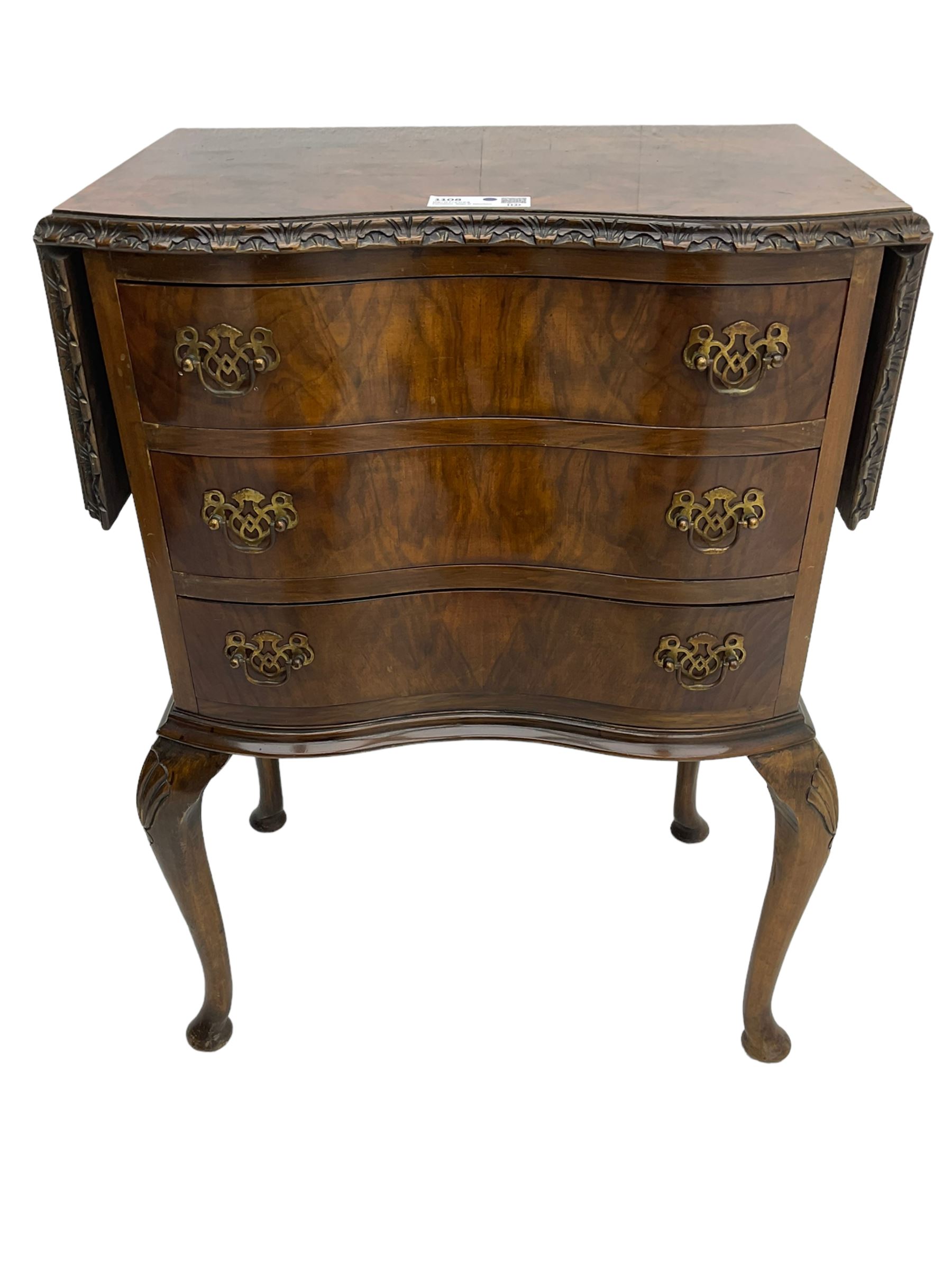 Early to mid-20th century figured walnut lamp table, shaped drop-leaf top with foliate carved edge, fitted with three drawers, on shell carved cabriole supports