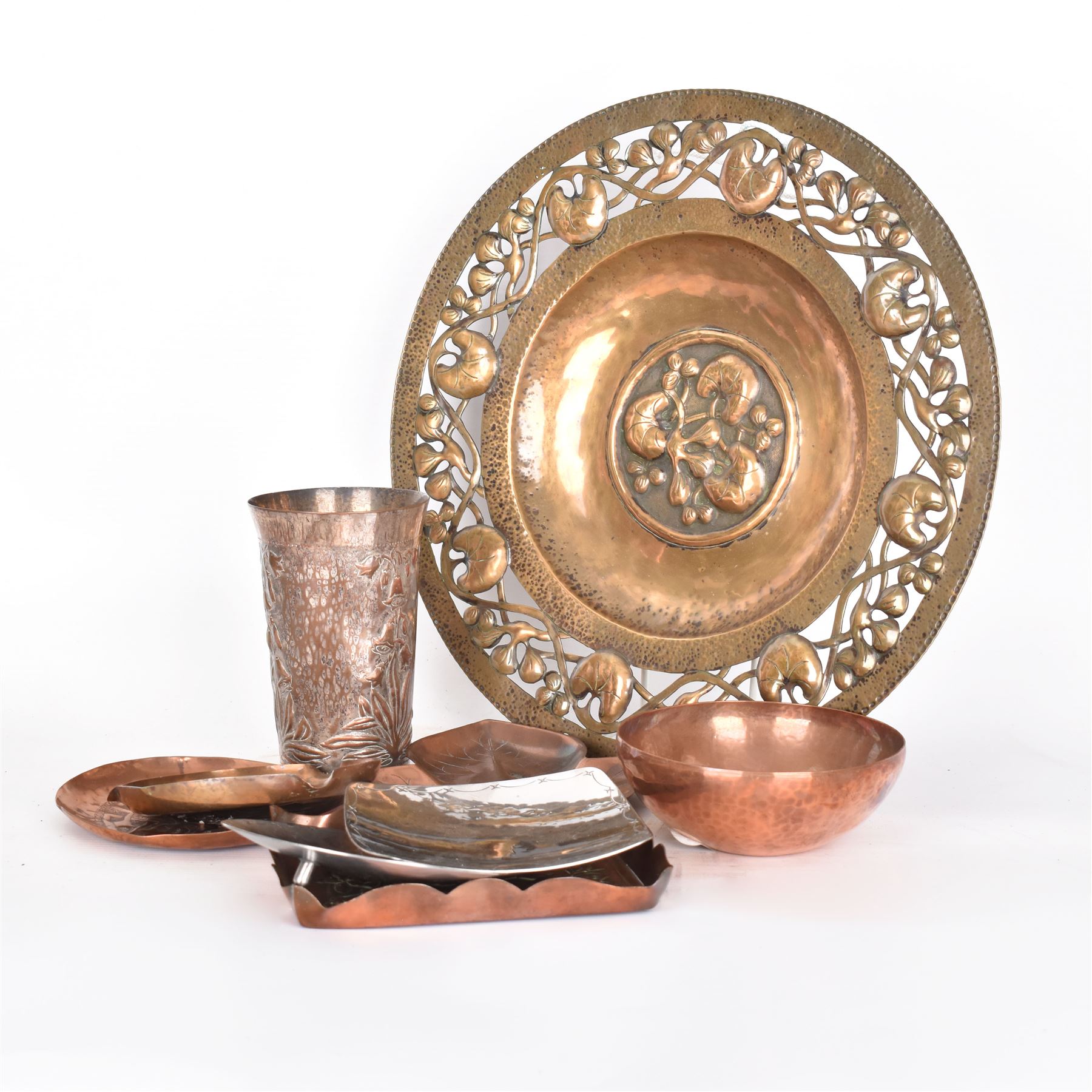 Keswick School of Industrial Arts, flared vase of cylindrical form, together with an Arts and Crafts plated copper, an embossed tray, copper dishes and charger 