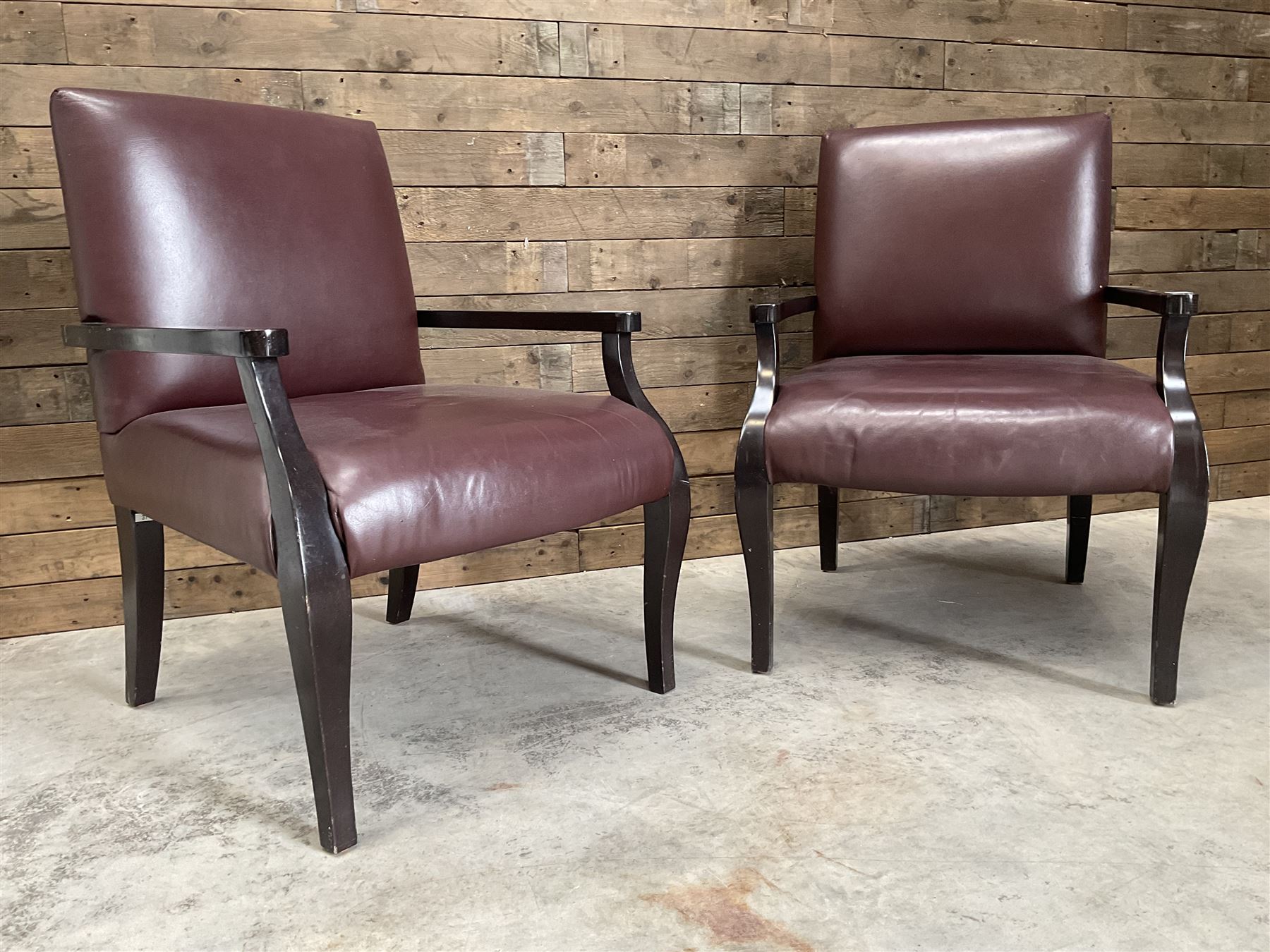 Two rosewood framed armchairs, upholstered in brown leather