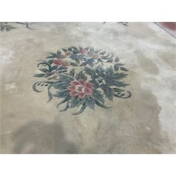 Chinese ivory ground washed woollen carpet, the field decorated with five large floral motifs with extending leafage, the wide rose guard band decorated with further floral patterns