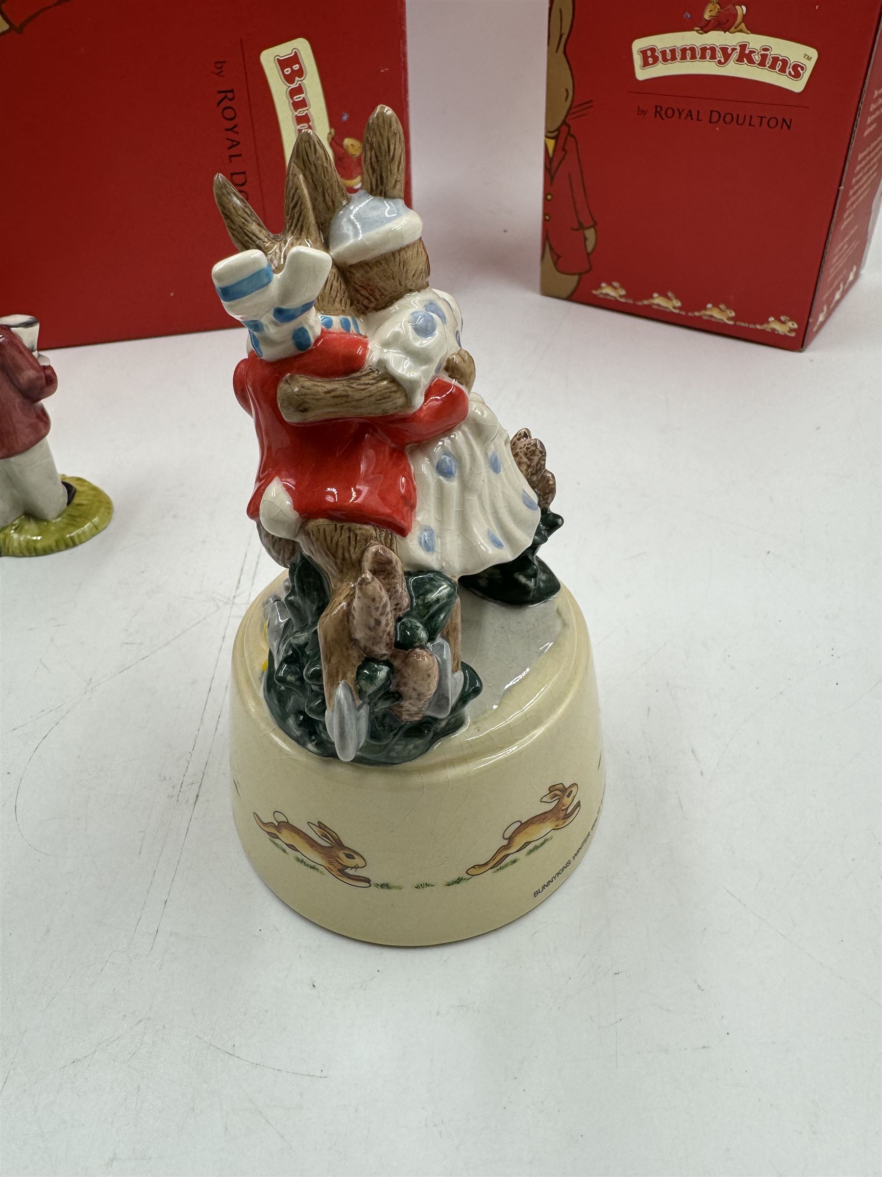 Two Royal Doulton Bunnykins music boxes, comprising Rocking Horse and Winter Waltz together with two Royal Doulton Bunnykins figures Once Upon a Time and Father, Mother & Victoria, all with original boxes  