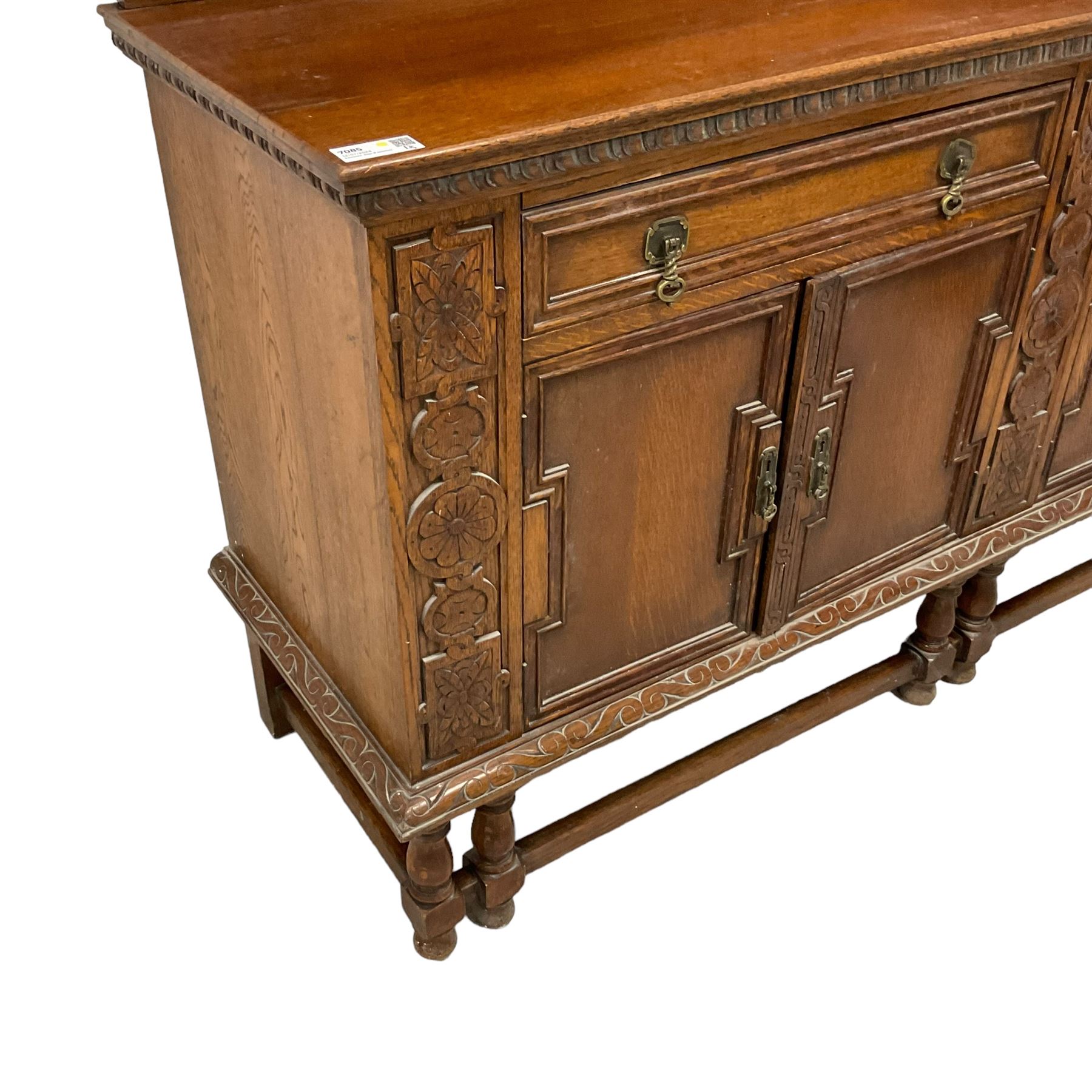 Early 20th century oak sideboard, raised panelled back with foliate carved decoration, rectangular top with gadrooned edge, fitted with two drawers over cupboards with field moulded facias, turned supports joined by stretchers