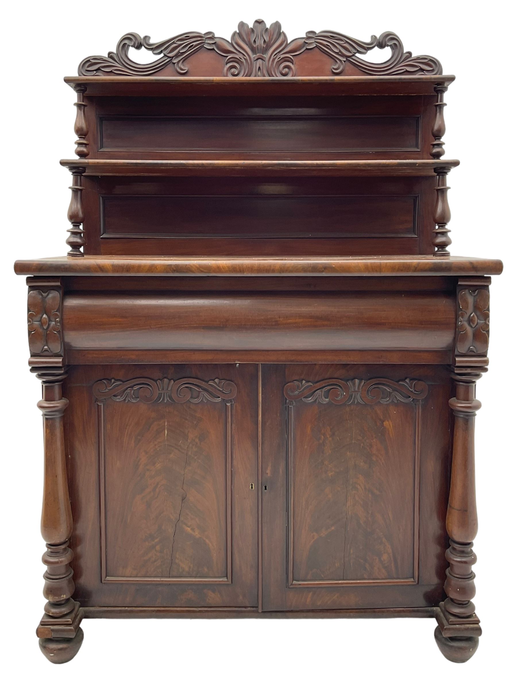 Victorian mahogany chiffonier, raised shaped pediment carved with scrolled extending foliage, two graduating shelves on turned supports, rectangular top over drawer and double cupboard, turned column pilasters, on turned feet 