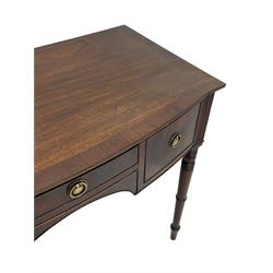 George III mahogany kneehole dressing or writing table, stepped bow-front form, reed moulded top with mahogany crossband, fitted with three cock-beaded drawers with circular pressed brass handle plates decorated with urn and beaded ring handle, on ring turned supports 