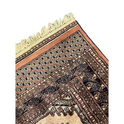 Persian peach ground rug, the field divided into four panels each with geometric lozenge, multiple band border with stylised flower head motifs, the end panels decorated with repeating lozenges