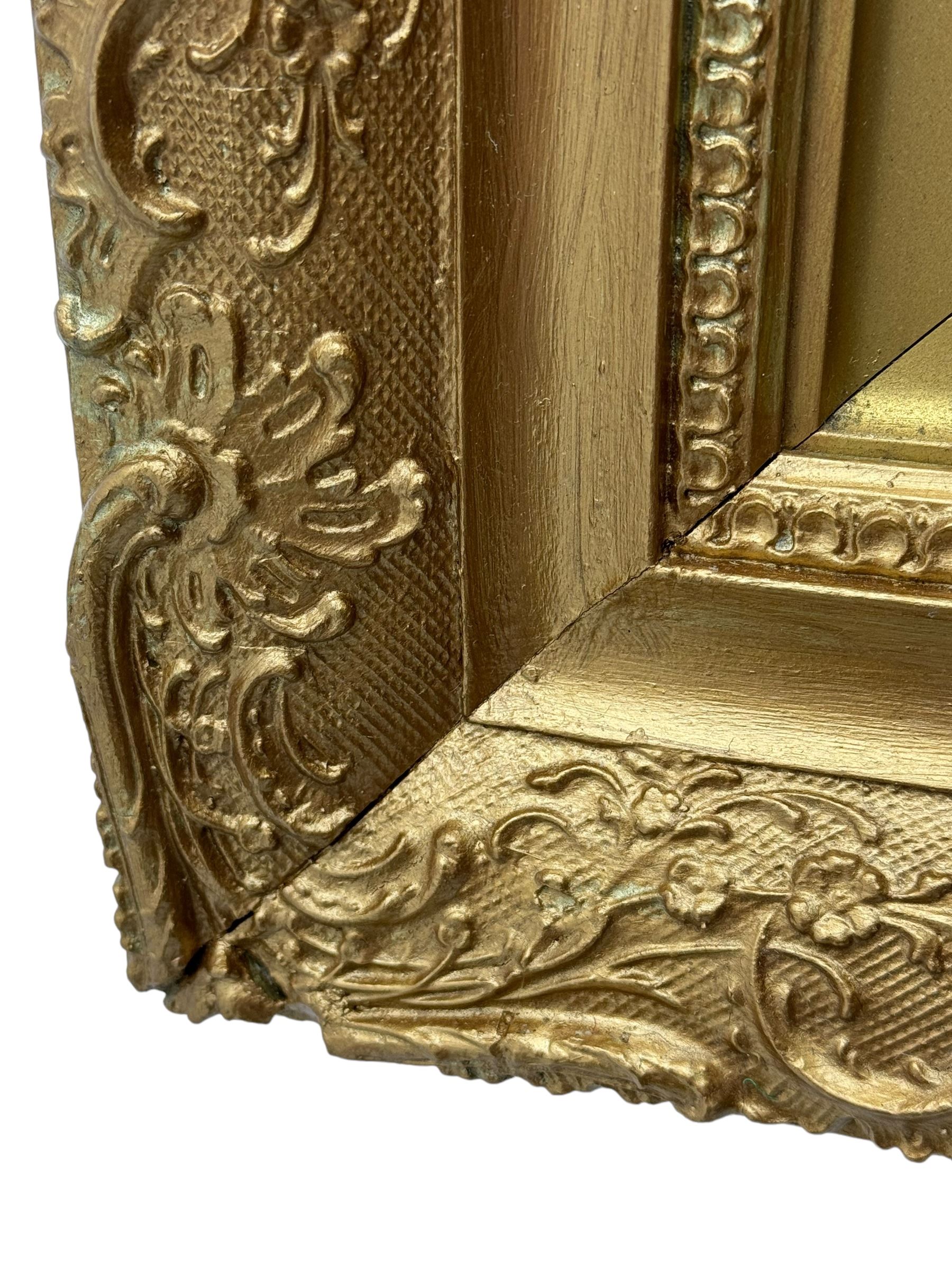 Rectangular wall mirror, in ornate gilt frame decorated with trailing leafy branches and flower heads 