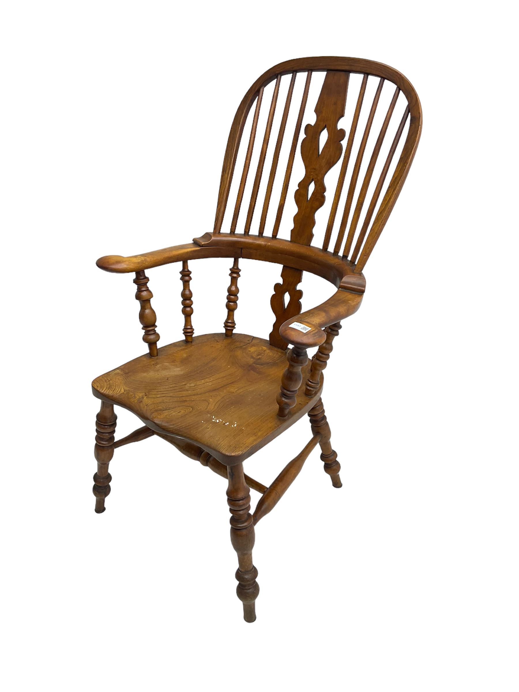 Elm and beech high back Windsor chair,  high hoop back with pierced splat and spindle supports over shaped saddle seat, raised on ring turned supports united by H-stretcher