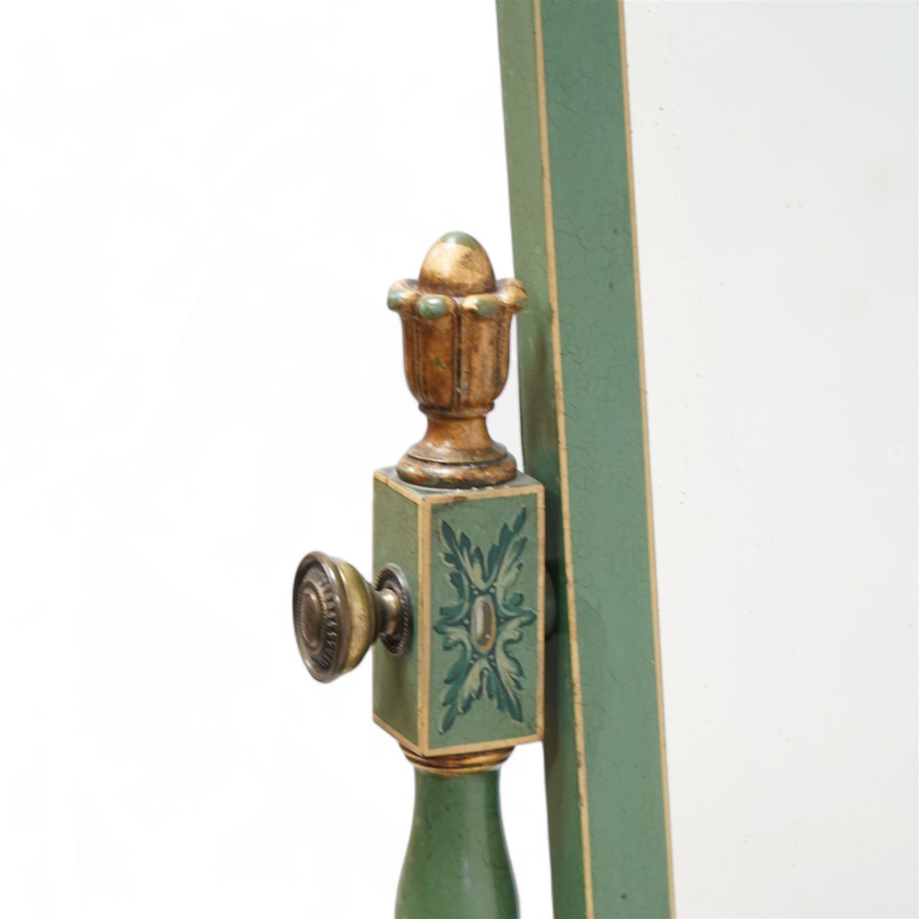 Edwardian Adam Revival green-painted and parcel gilt cheval mirror, shaped pediment painted with urn and flower head festoons, turned supports with carved finials decorated with acanthus leaves and draped festoons, on out splayed supports with spade feet and brass castors 