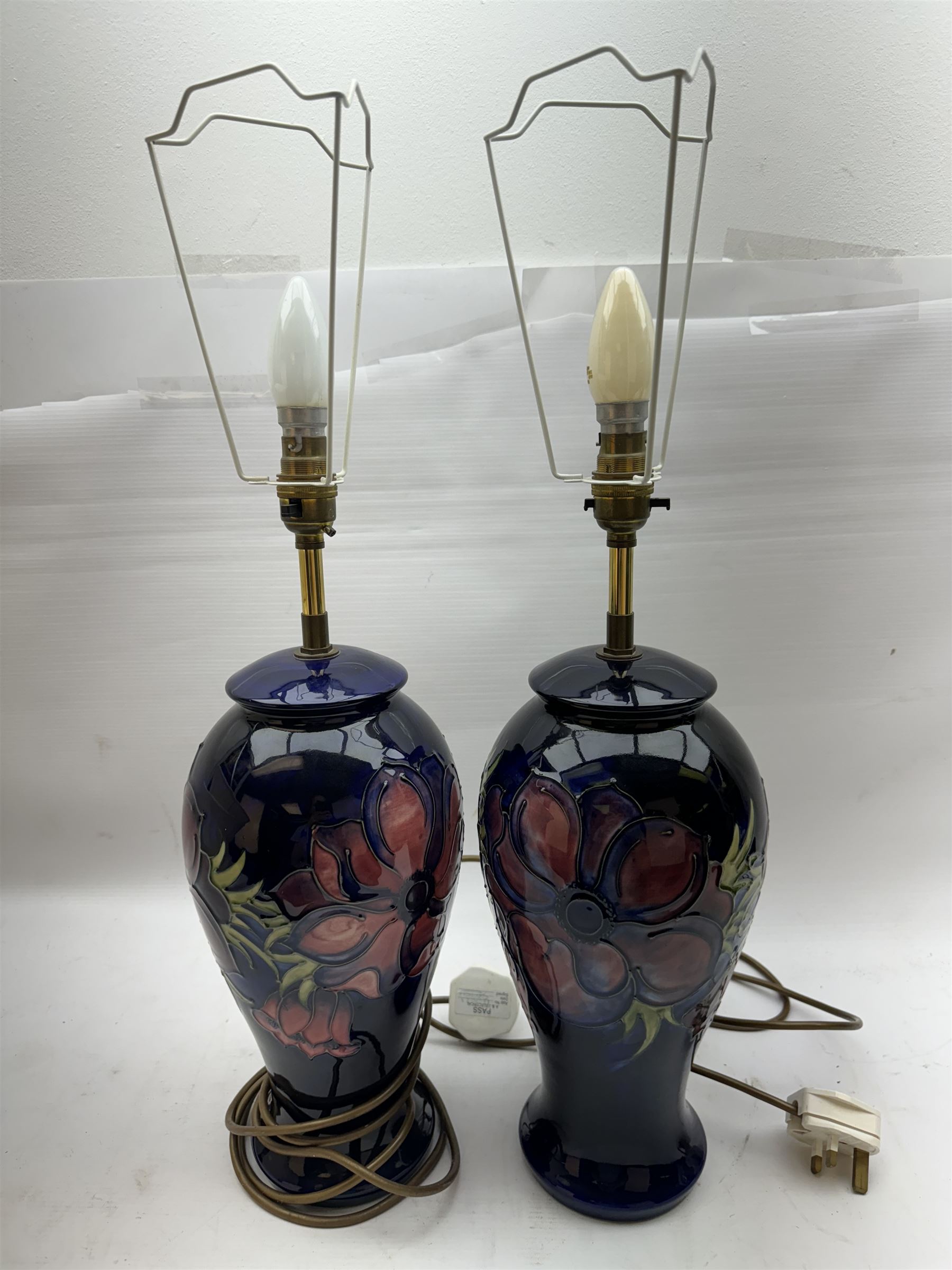 Pair of Moorcroft table lamps, in Anemone patter, upon a blue ground, with cream lampshades, H68