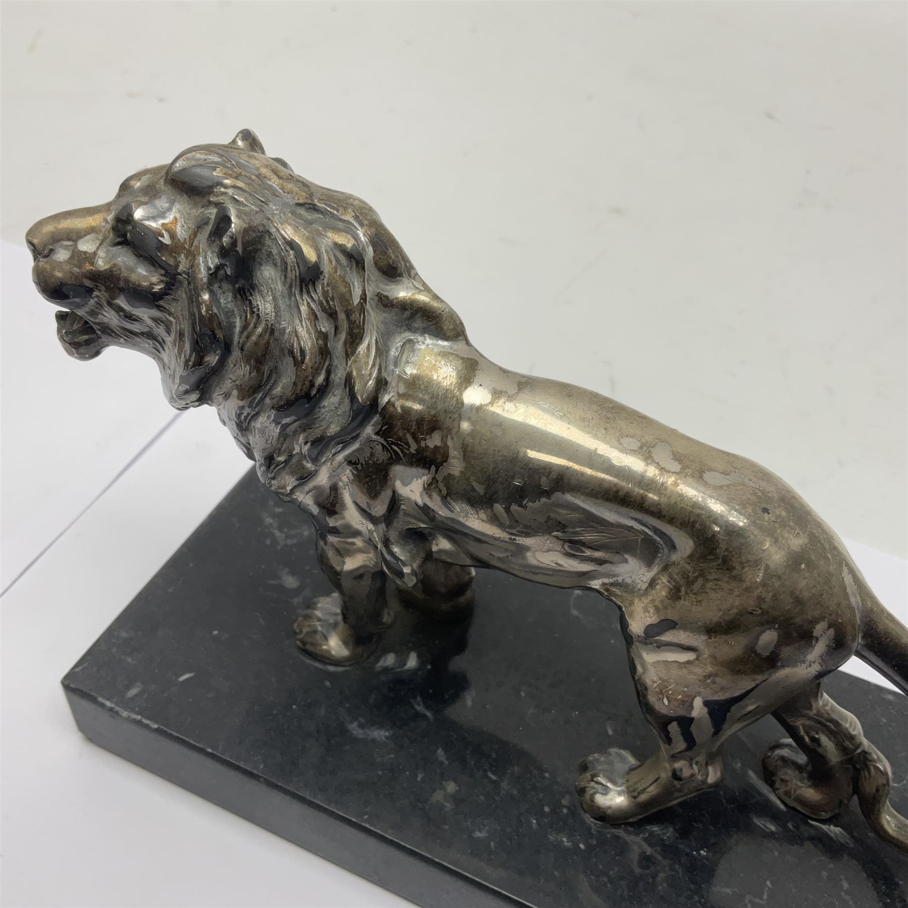 Silvered metal lion, upon a rectangular base, H12cm