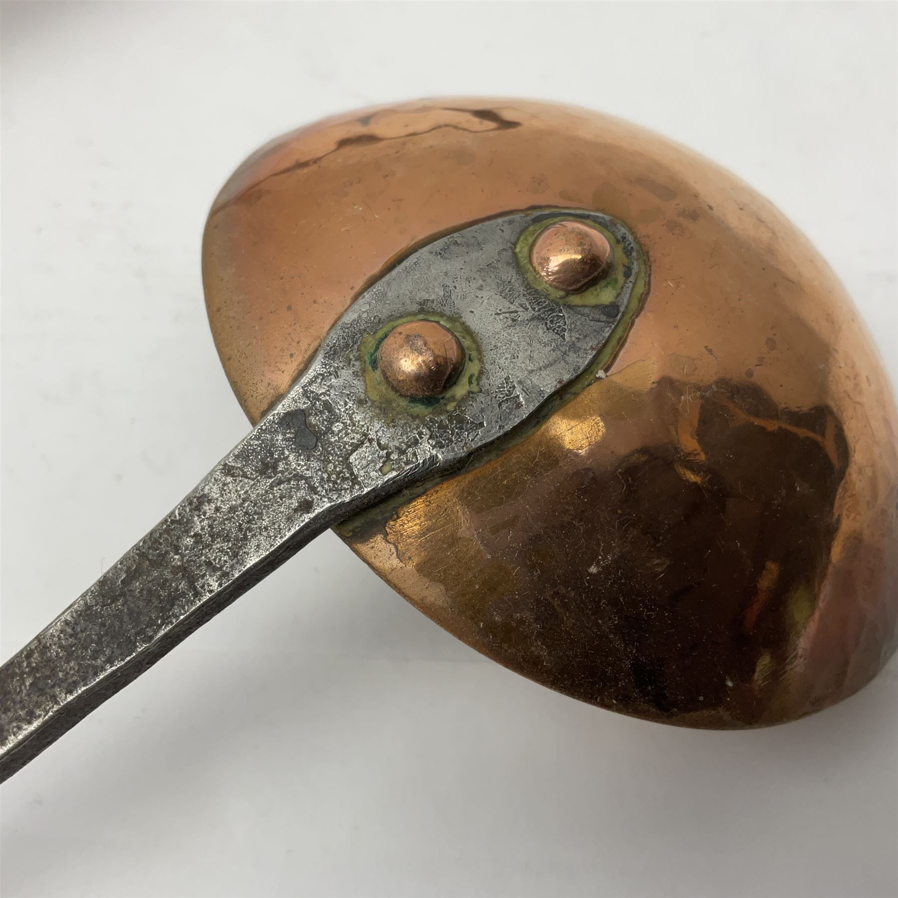 Large 19th century copper slotted spoon, with pierced flat bowl, L55cm, together with two 19th century iron handled ladles with circular copper bowls, largest example L48.5cm, (3)