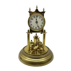 Continental- early-20th century torsion clock under a glass dome, movement raised on two pillars on a circular brass base, with an enamel dial, Roman numerals and spade hands, oscillating four ball circular pendulum. Torsion spring intact.