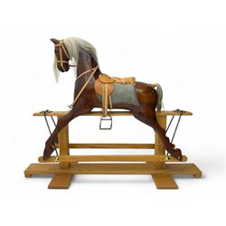 Contemporary carved wooden rocking horse, with leather saddle and bridle, horsehair mane a...