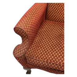 Early 20th century hardwood-framed wingback armchair, upholstered in red dotted fabric, on cabriole feet