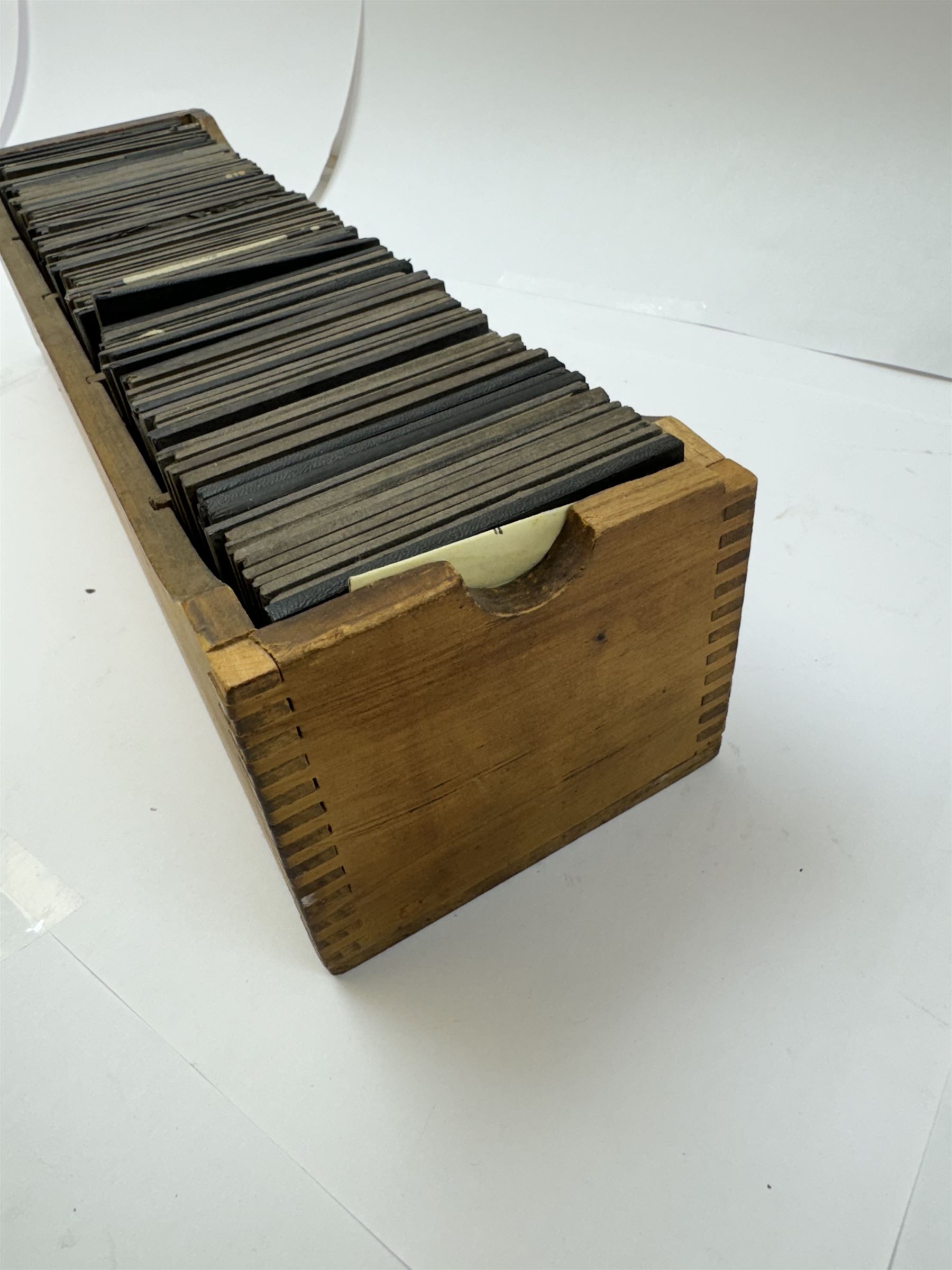 Collection of magic lantern slides, predominantly depicting views of India, with scenes including including the Taj Mahal, tombs, monuments, street scenes, people and animals, in compartmentalised wooden case 