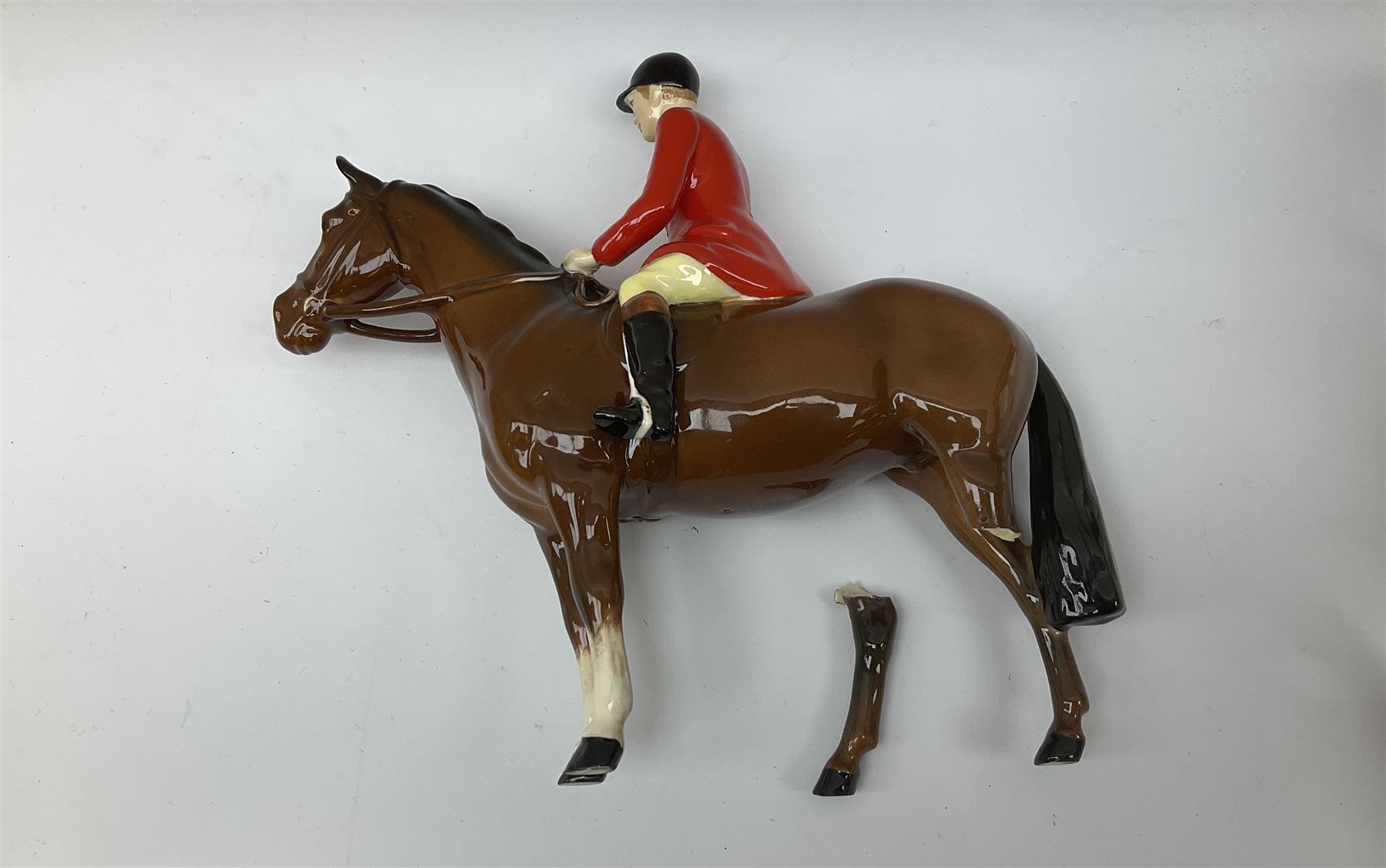 Beswick Hunting Group, comprising: two huntswoman on grey horses, model no 1730, huntsman on a bay horse, model no 1501, a seated fox, model no 1748, eighteen fox hounds and a spaniel, model no 967, all with printed marks beneath, together with three other ceramic huntsman on horseback and two hounds. 