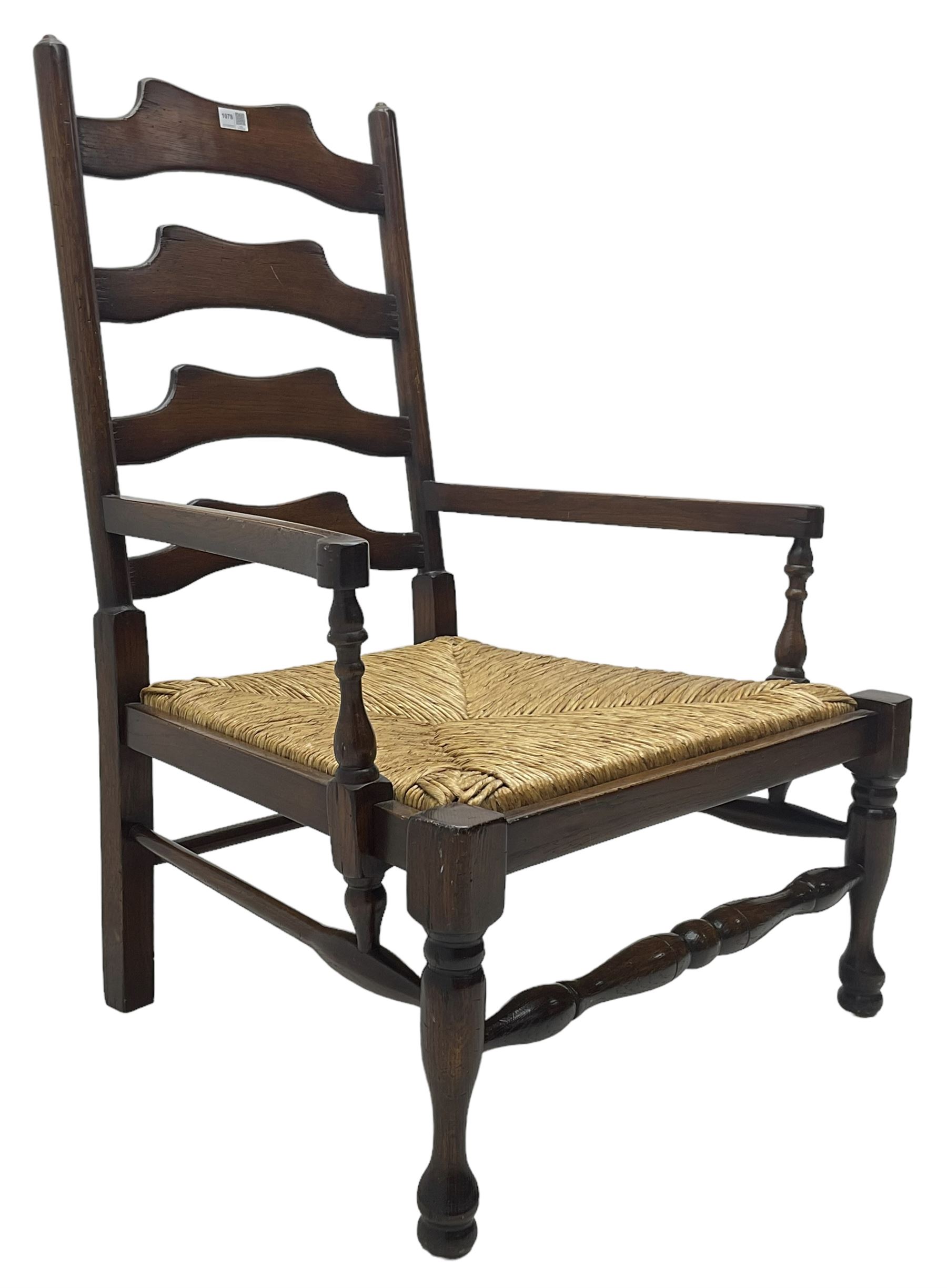 Georgian design oak country low armchair, waived ladder back over rush seat, raised on turned  supports united by stretchers; together with matching stool