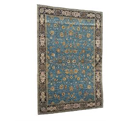 Persian Nain blue ground rug, overall arabesque design, the busy field decorated with interlacing branches and palmettes, indigo ground border with panels decorated with knots and lotus flower motifs, surrounded by trailing branches and flower heads, within guard stripes