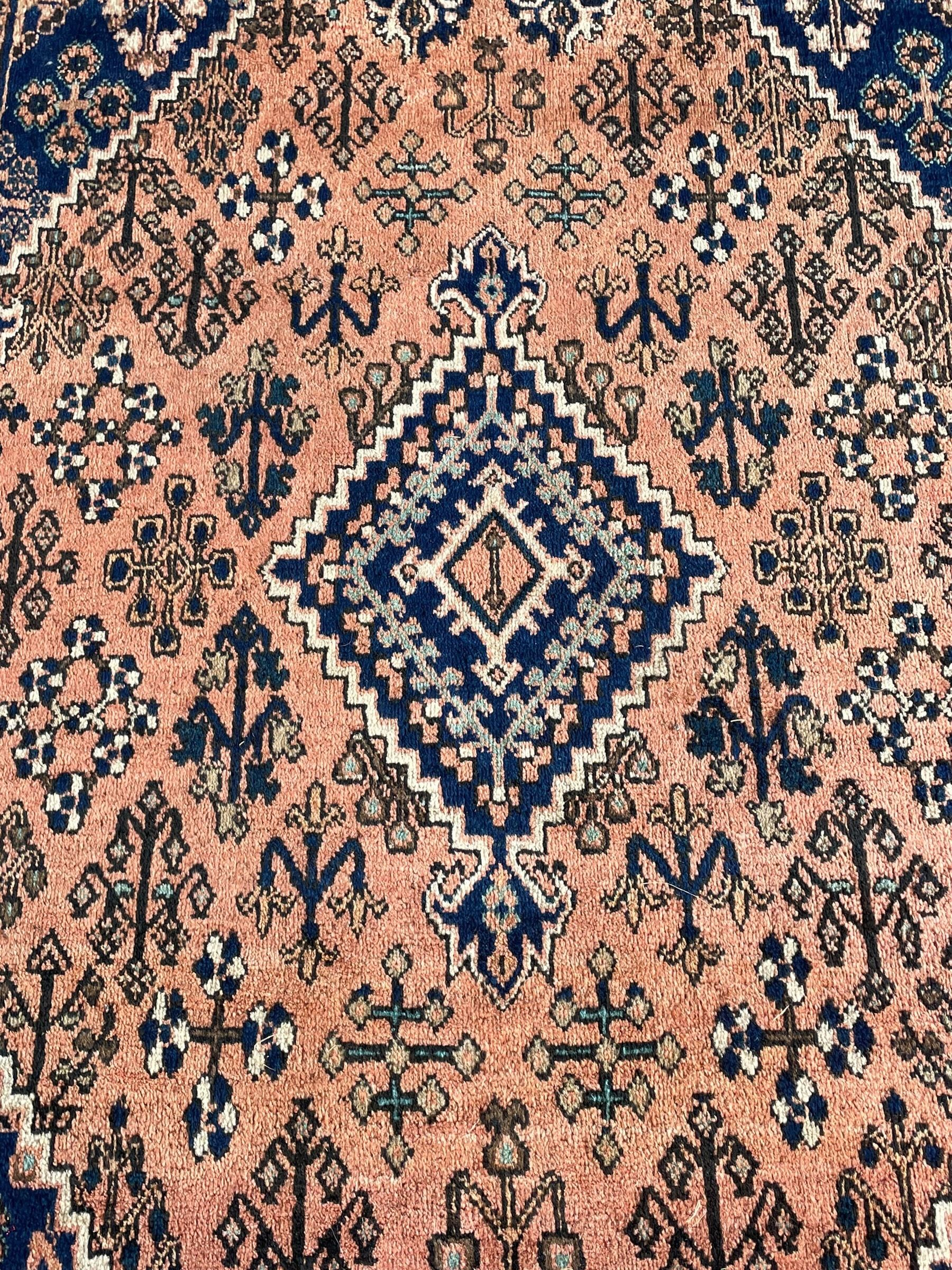 Persian Joshaghan peach and blue ground rug, central stepped lozenge medallion surrounded by bunches of floral motifs, repeating border decorated with stylised plant motifs, within multiple guard stripes