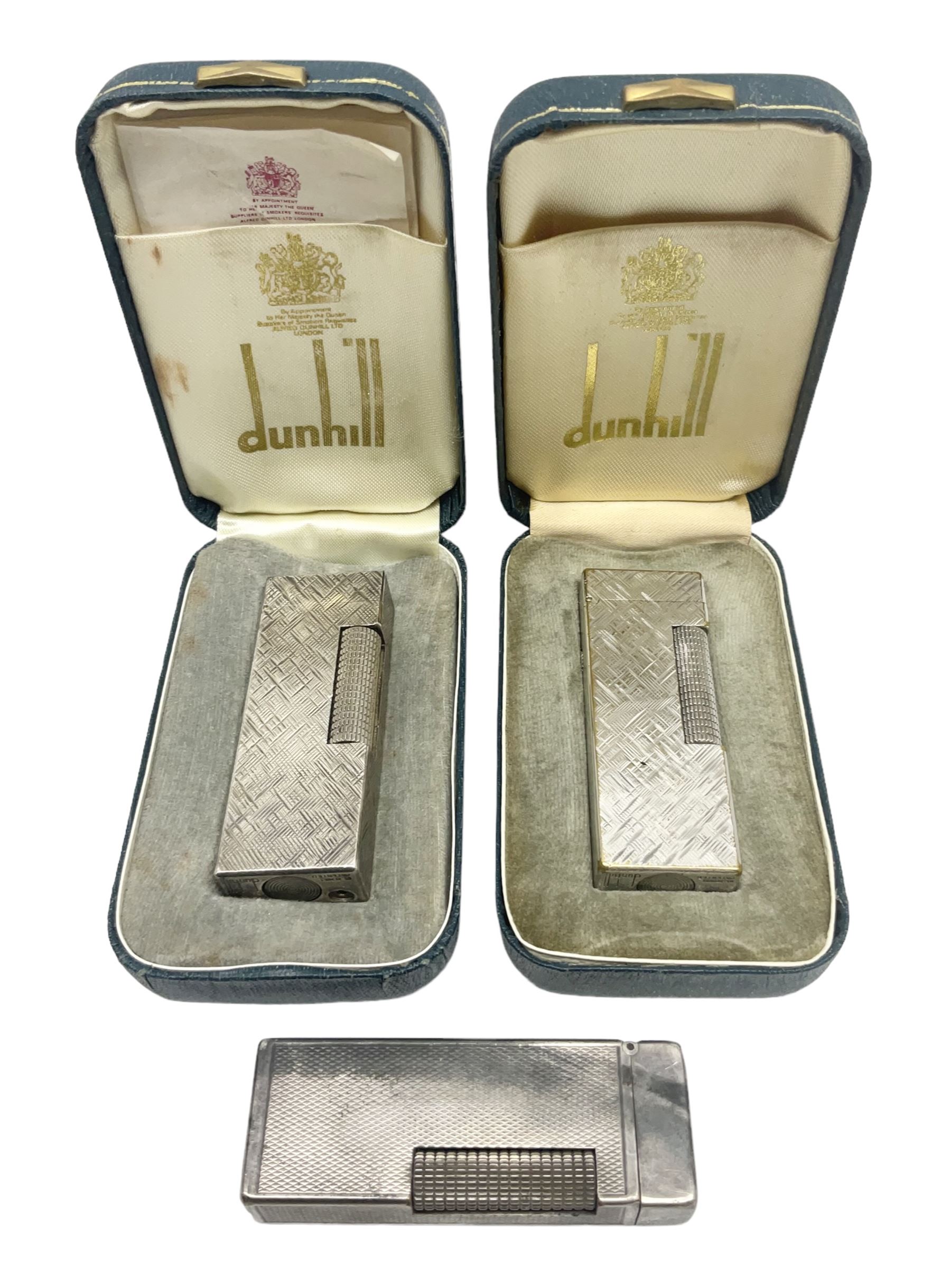 Three Dunhill silver plated lift-arm lighters, of rectangular form with engine turned decoration, marked Dunhill, two with original cases 