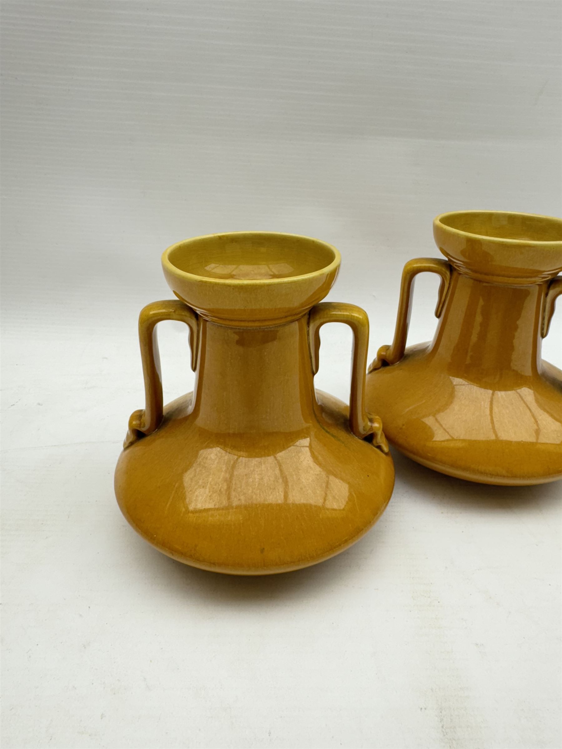 Christopher Dresser for Linthorpe Pottery, pair of twin handled vases, ochre glaze, H14cm