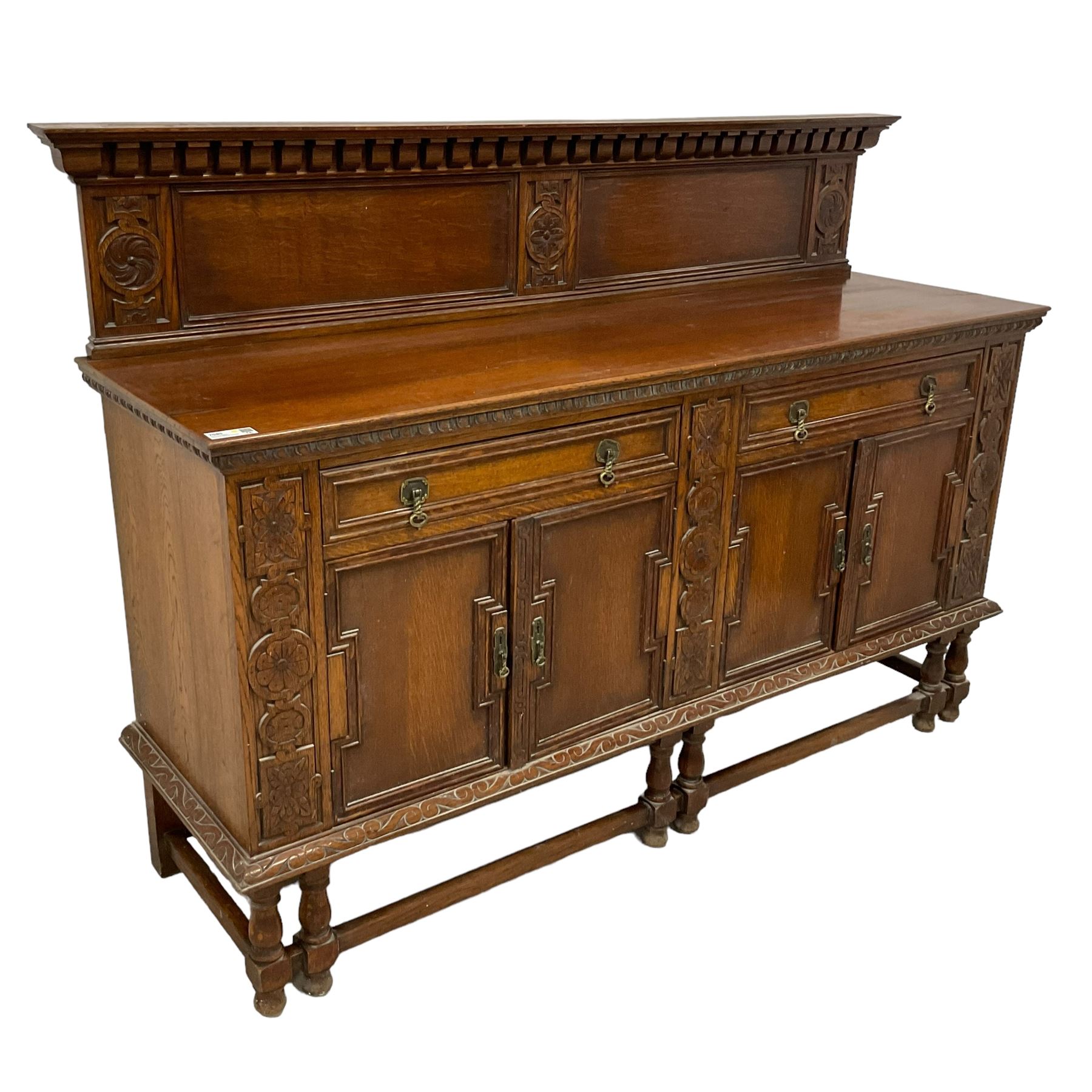 Early 20th century oak sideboard, raised panelled back with foliate carved decoration, rectangular top with gadrooned edge, fitted with two drawers over cupboards with field moulded facias, turned supports joined by stretchers